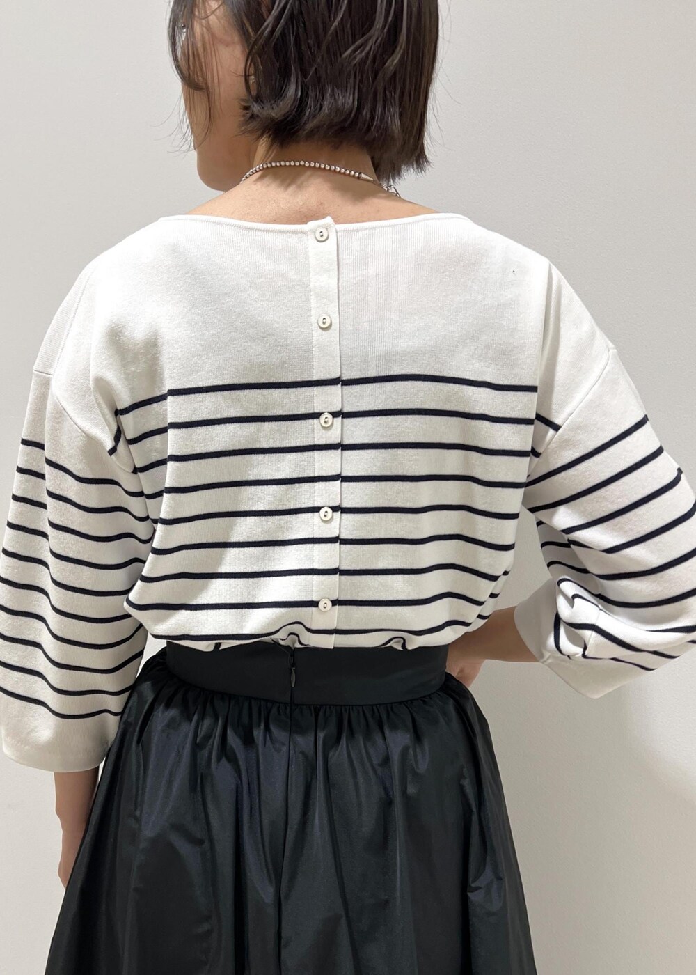 グリーン系のハンドバッグ、ホワイト系のパンプス、ブラック系のスカートを着用したレディースの春コーディネートの7枚目の写真