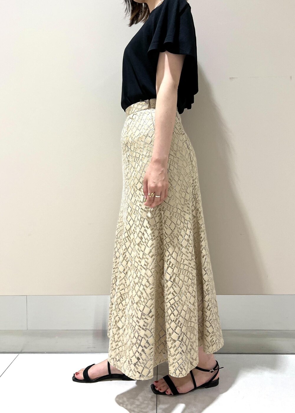 ベージュ系のハンドバッグ、ブラック系のニット/セーター、ベージュ系のスカートを着用したレディースの春コーディネートの5枚目の写真