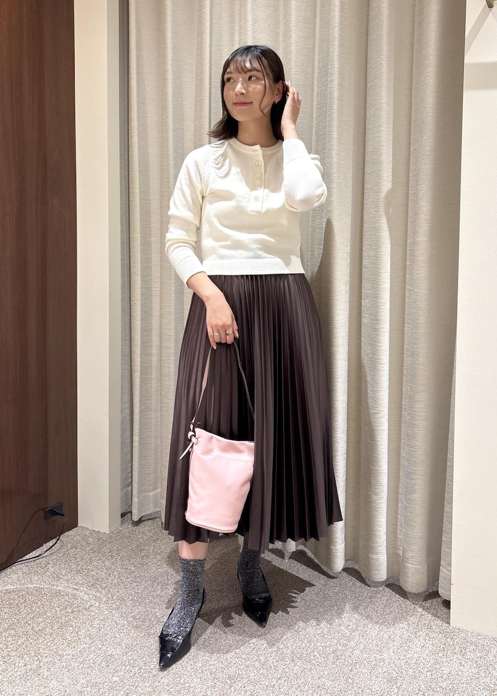 ピンク系のハンドバッグ、ブラウン系のスカート、ホワイト系のニット/セーターを着用したレディースの春コーディネートの2枚目の写真