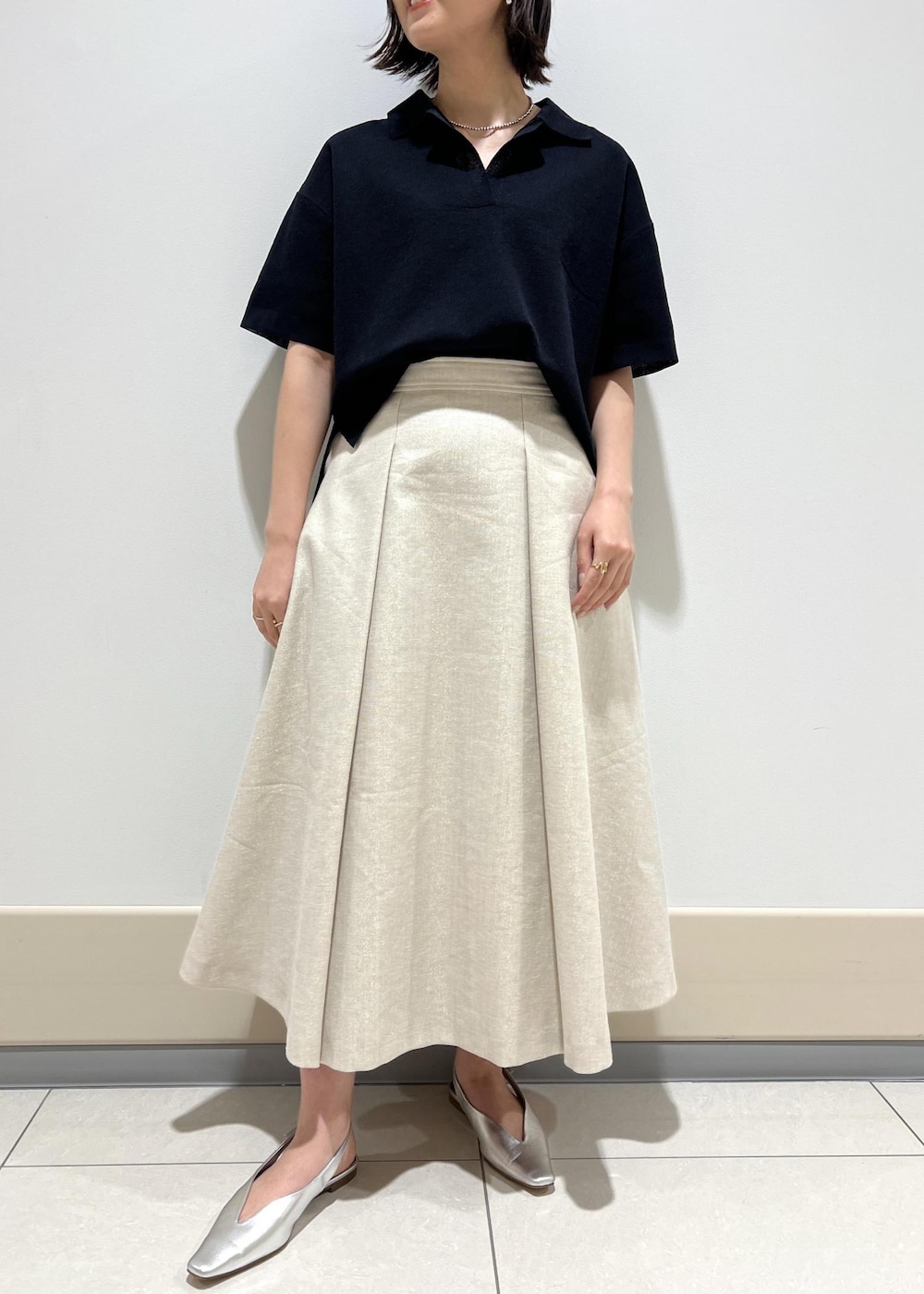 ブラック系のハンドバッグ、シルバー系のパンプス、ブルー系のニット/セーターを着用したレディースの春コーディネートの5枚目の写真