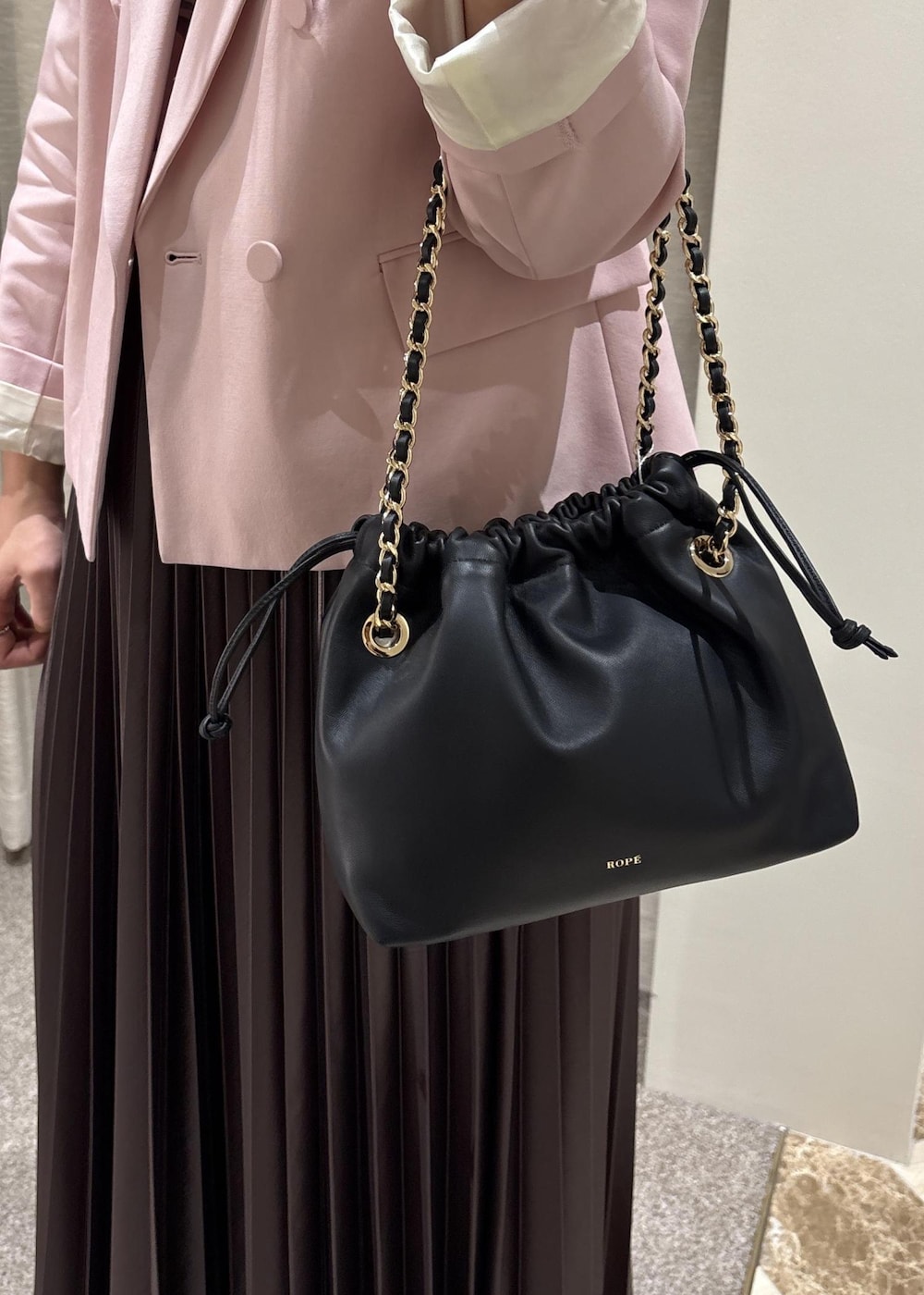 ホワイト系のTシャツ/カットソー、ブラック系のハンドバッグ、ピンク系のテーラードジャケットを着用したレディースの春コーディネートの7枚目の写真