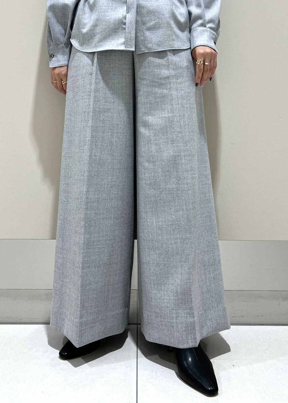 イエロー系のトートバッグ、ブラック系のブーツ、グレー系のシャツ/ブラウスを着用したレディースの秋コーディネートの8枚目の写真