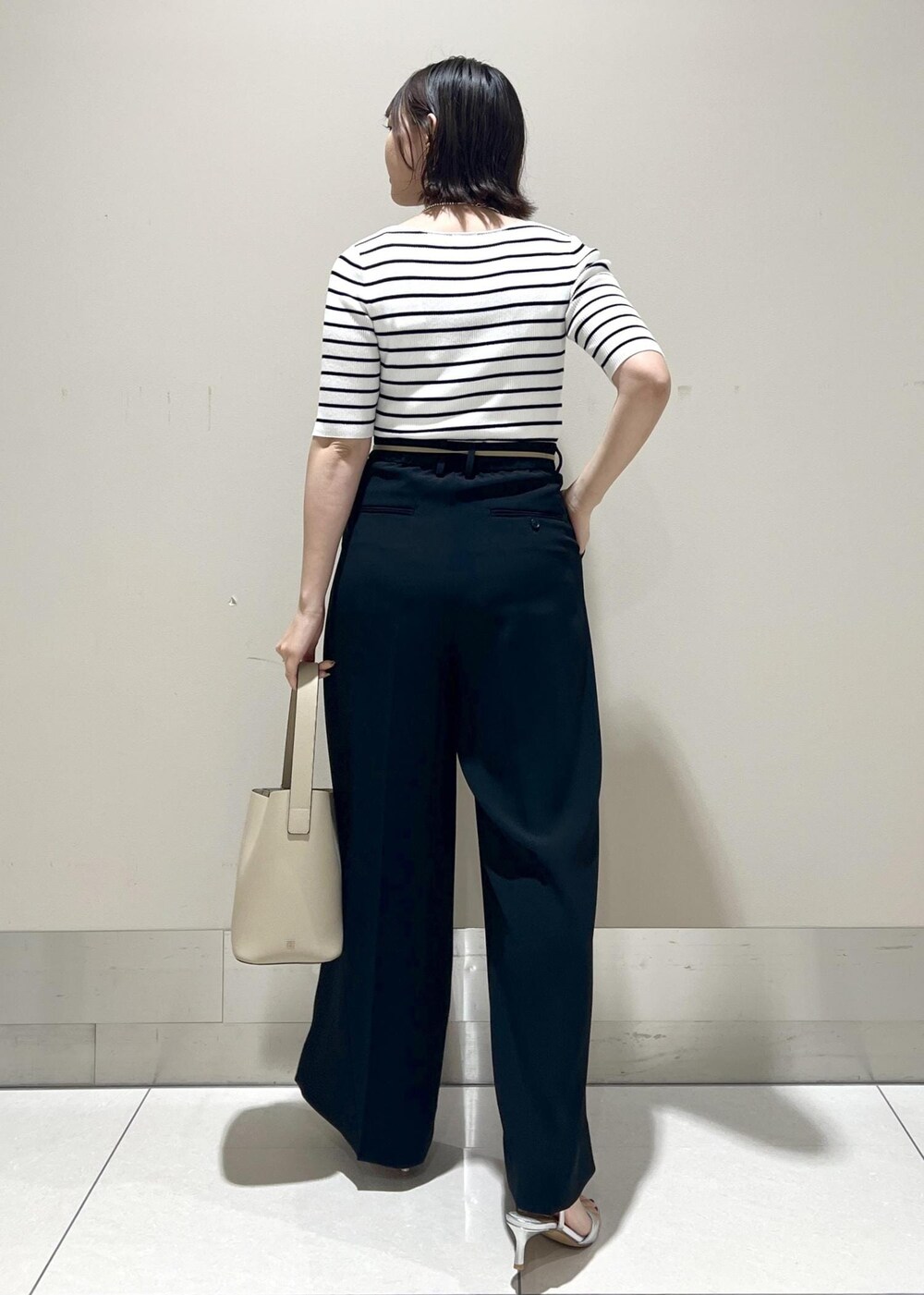 シルバー系のサンダル、ホワイト系のTシャツ/カットソー、ベージュ系のハンドバッグを着用したレディースの春コーディネートの4枚目の写真