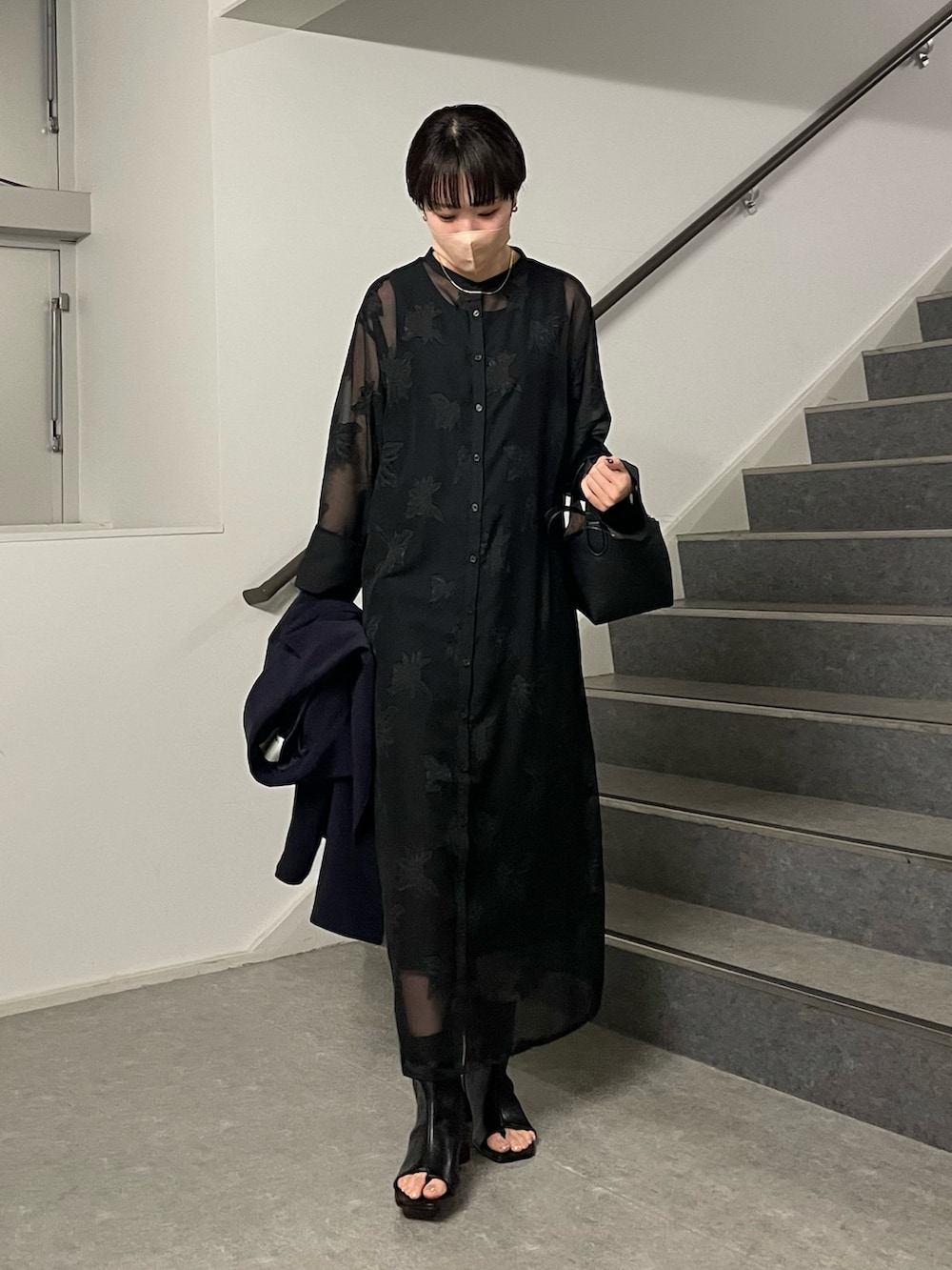 ホワイト系のトートバッグ、ブラック系のワンピース、ブルー系のテーラードジャケットを着用したレディースの冬コーディネートの2枚目の写真