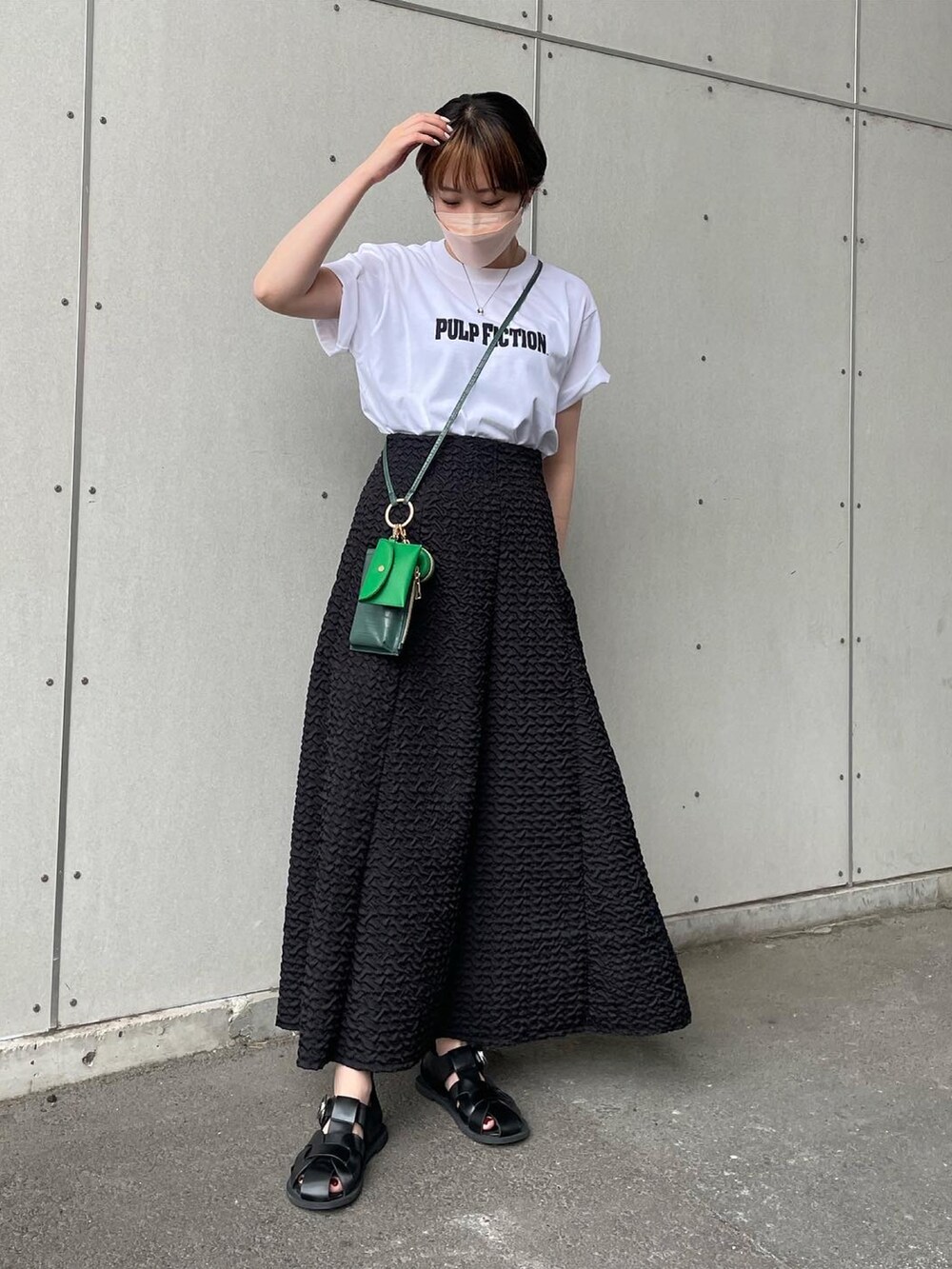 ブラック系のスカート、ブラック系のサンダルを着用したレディースの夏コーディネートの2枚目の写真