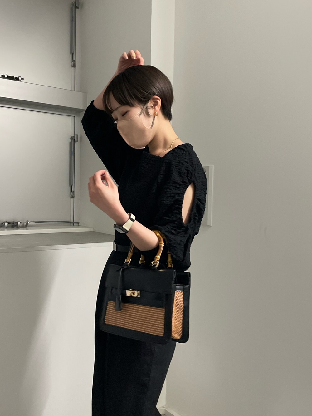 ブラック系のシャツ/ブラウス、ブラック系のデニムパンツ、ブラック系のハンドバッグを着用したレディースの春コーディネートの2枚目の写真