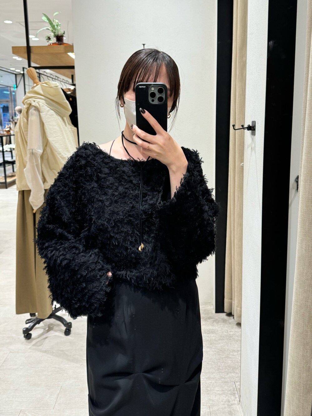 ブラック系のニット/セーター、ブラック系のスカート、ブラック系のパンプスを着用したレディースの秋コーディネートの2枚目の写真