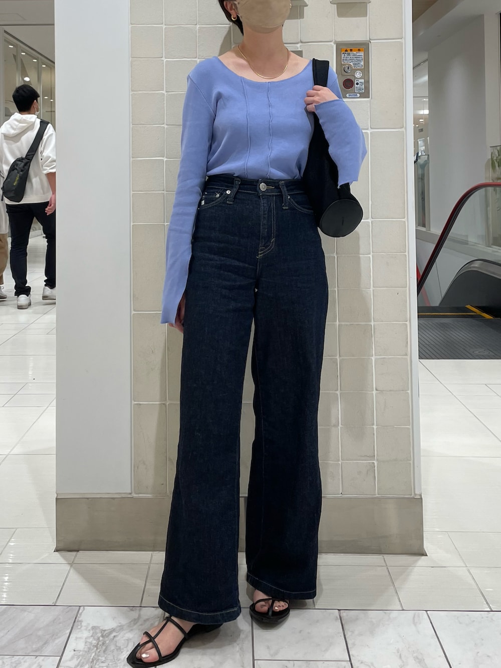 ブルー系のTシャツ/カットソー、ブルー系のデニムパンツ、イエロー系のハンドバッグを着用したレディースの春コーディネートの2枚目の写真