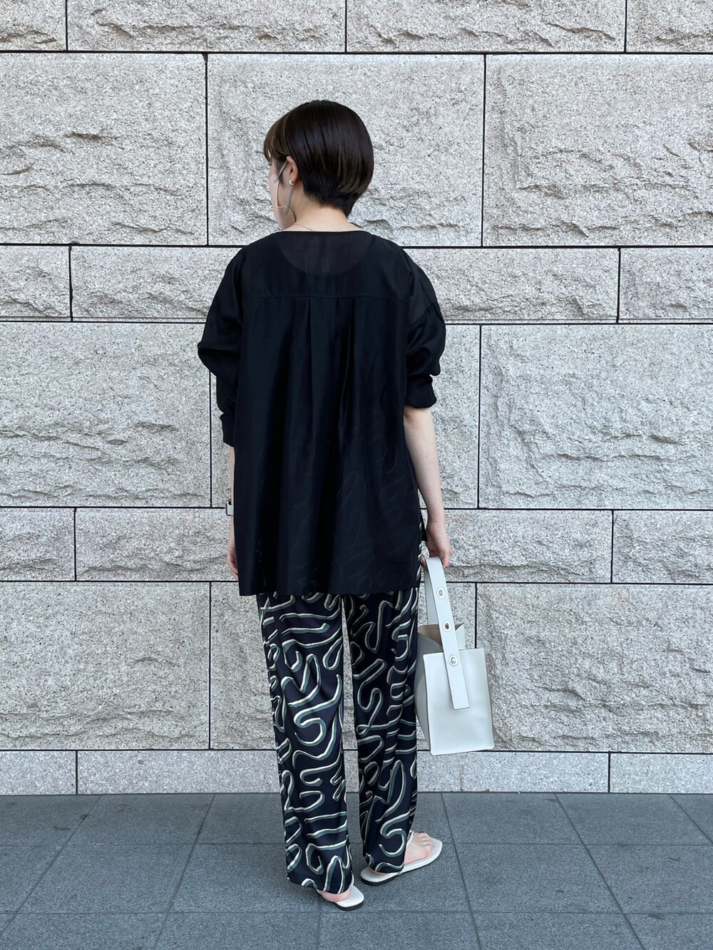 ホワイト系のトートバッグ、ブラック系のシャツ/ブラウス、ブラック系のその他パンツを着用したレディースの夏コーディネートの2枚目の写真