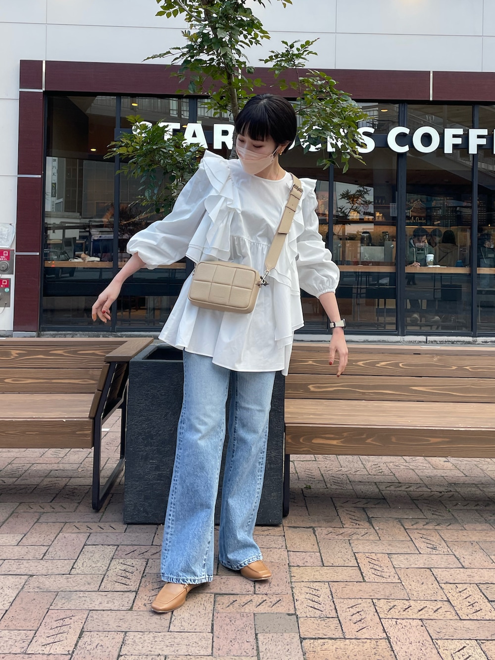 ホワイト系のシャツ/ブラウス、ブルー系のデニムパンツ、ベージュ系のローファーを着用したレディースの冬コーディネートの2枚目の写真