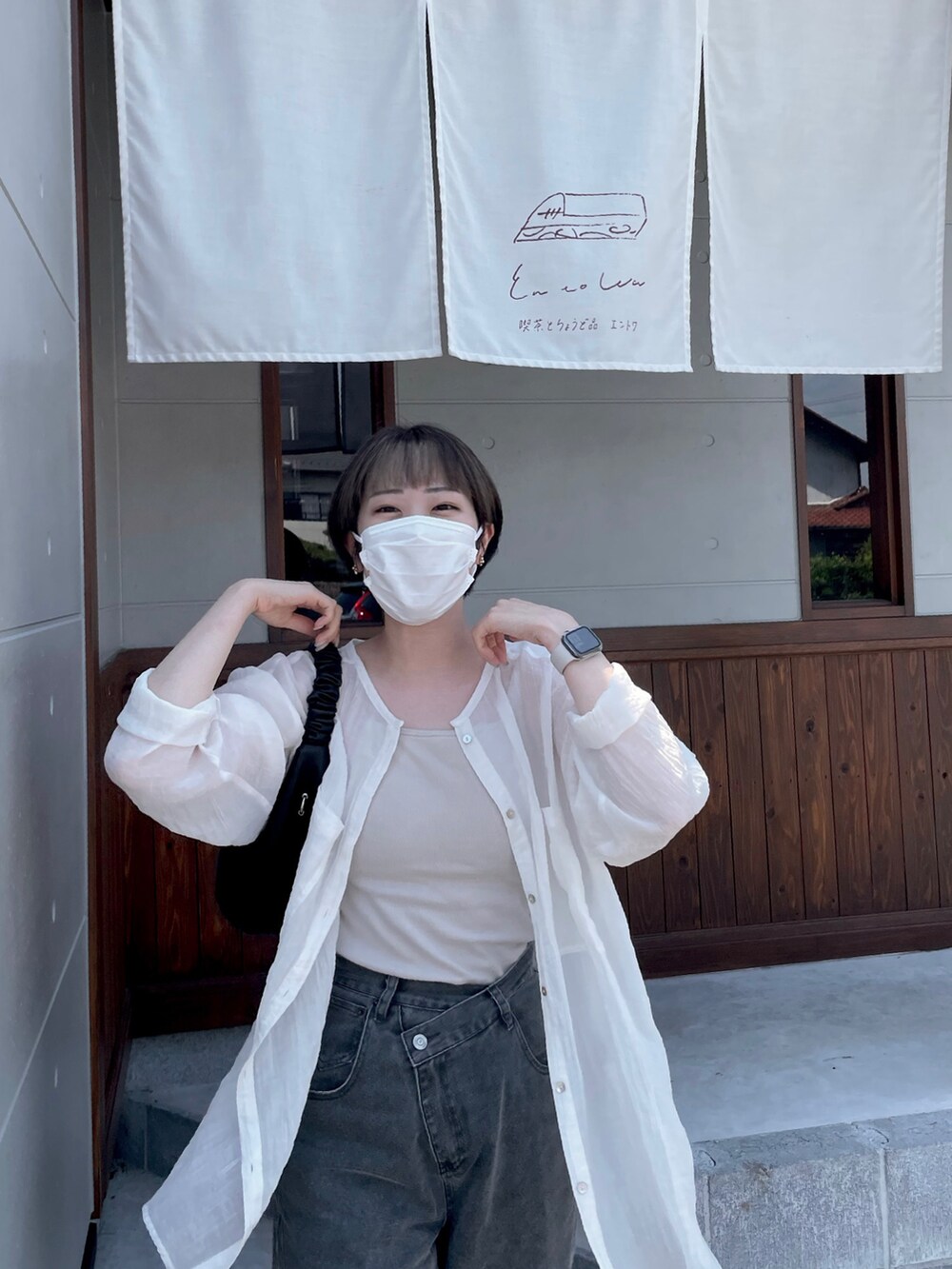 グレー系のデニムパンツを着用したレディースの夏コーディネートの2枚目の写真