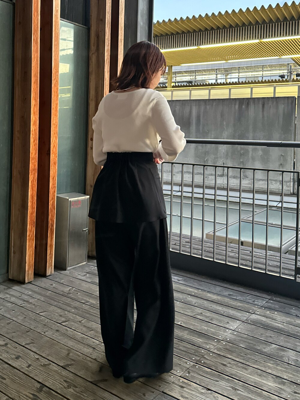 ブラック系のその他パンツ、ホワイト系のTシャツ/カットソー、ベージュ系のショルダーバッグを着用したレディースの春コーディネートの2枚目の写真