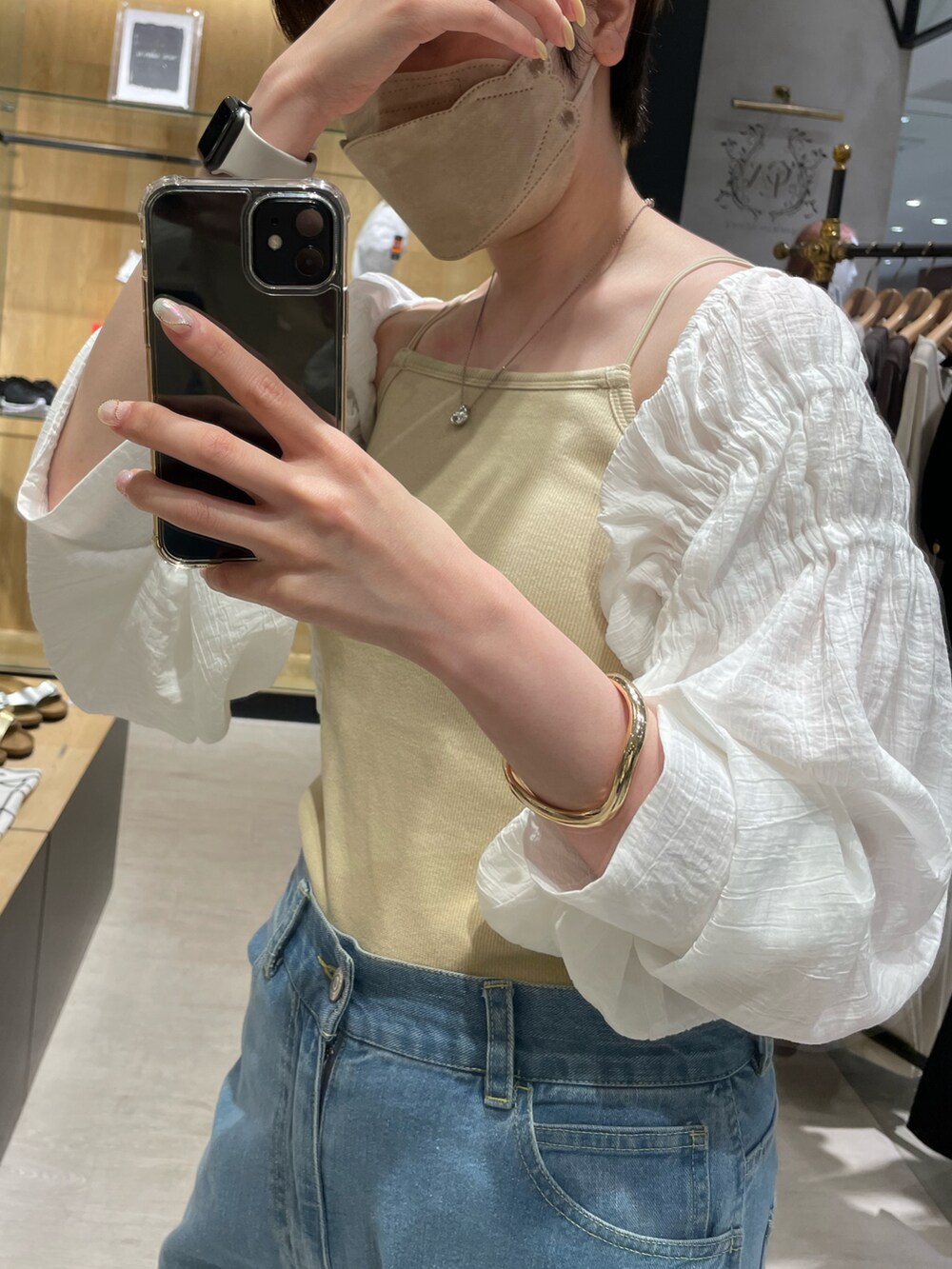 ホワイト系のシャツ/ブラウス、ブルー系のデニムパンツ、ベージュ系のハンドバッグを着用したレディースの春コーディネートの2枚目の写真