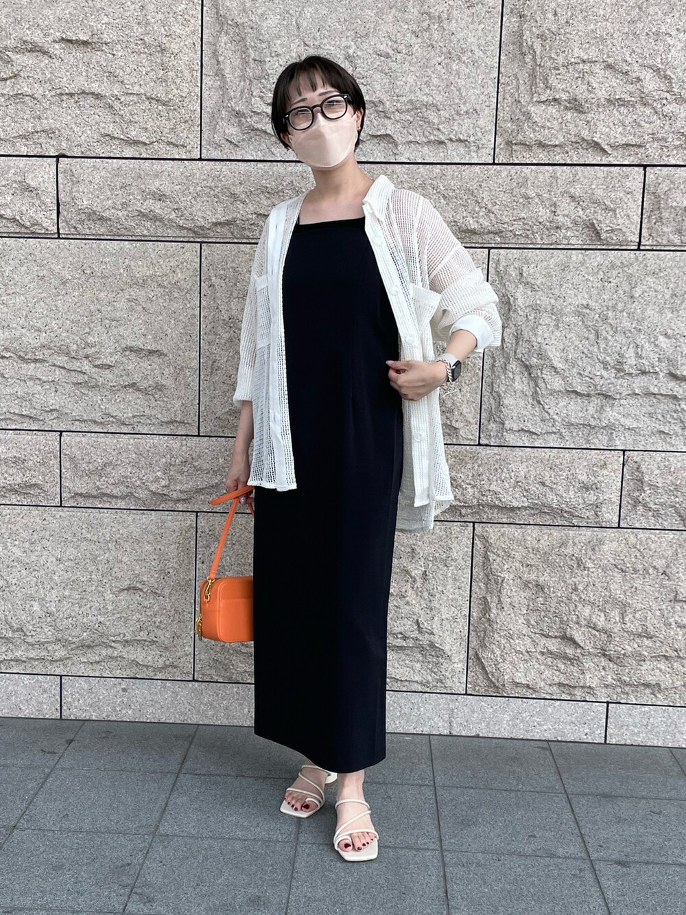 ブラック系のワンピース、ホワイト系のシャツ/ブラウス、ホワイト系のサンダルを着用したレディースの夏コーディネートの2枚目の写真