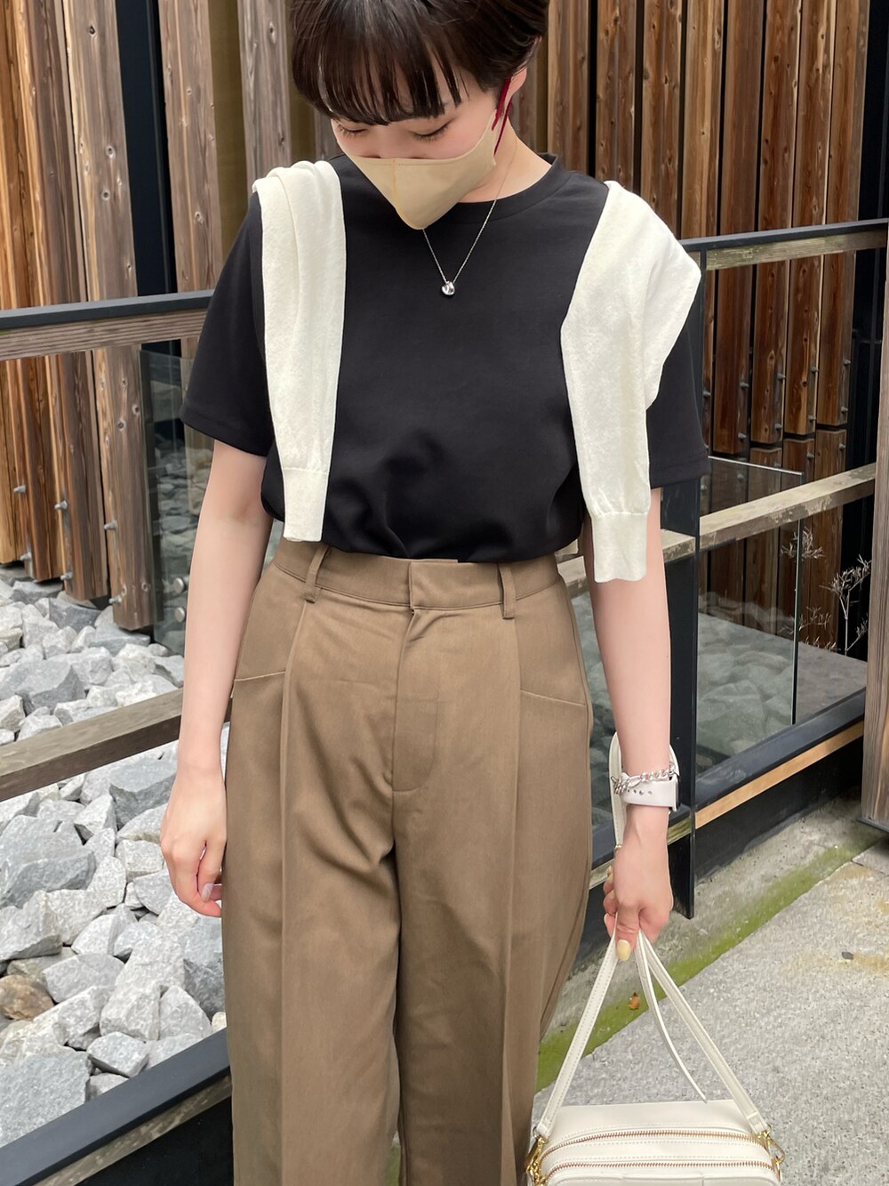 ブラック系のTシャツ/カットソー、ブラウン系のスラックス、ホワイト系のスニーカーを着用したレディースの春コーディネートの3枚目の写真