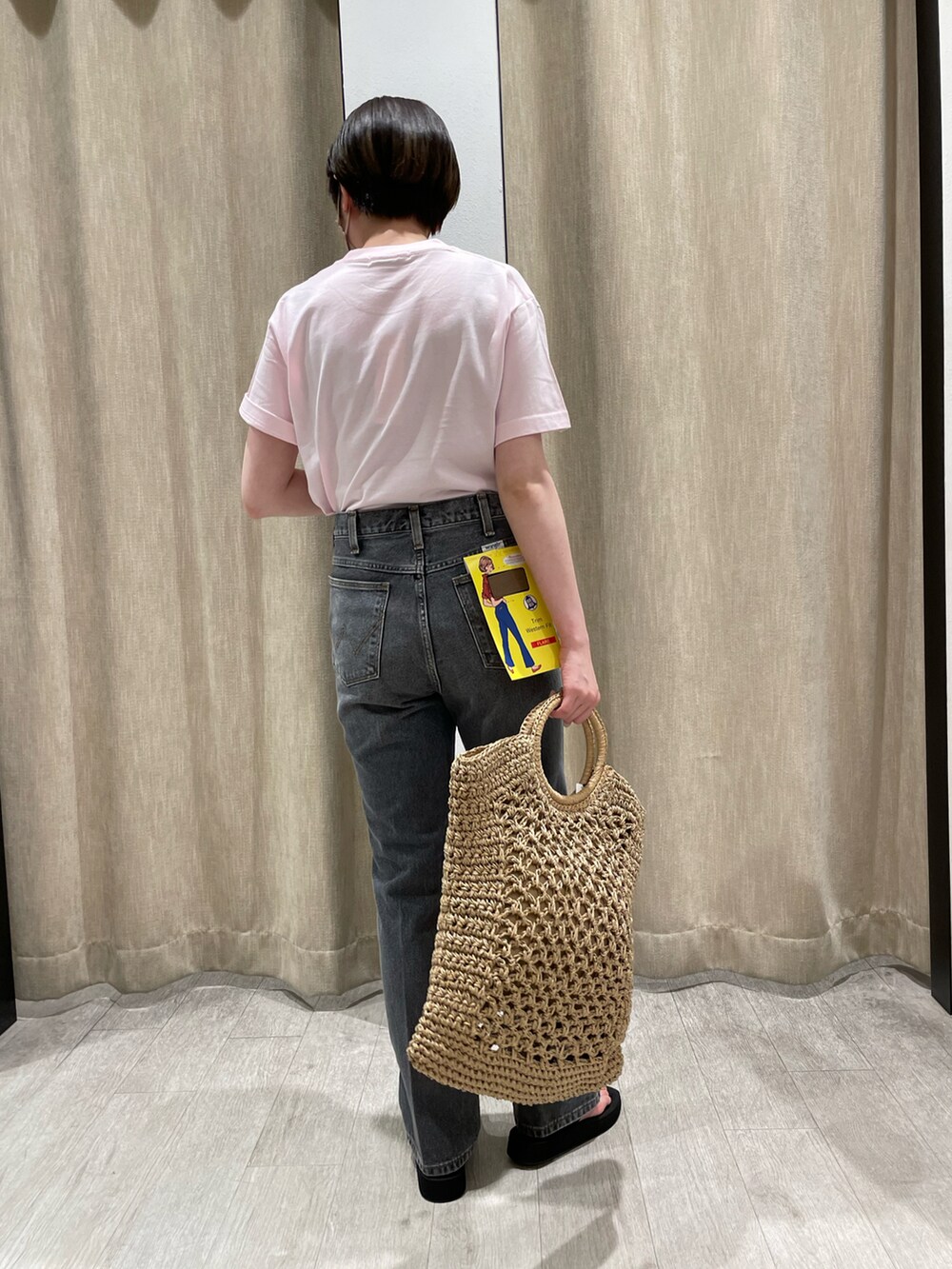 ピンク系のTシャツ/カットソー、ブラック系のデニムパンツ、ベージュ系のトートバッグを着用したレディースの春コーディネートの2枚目の写真