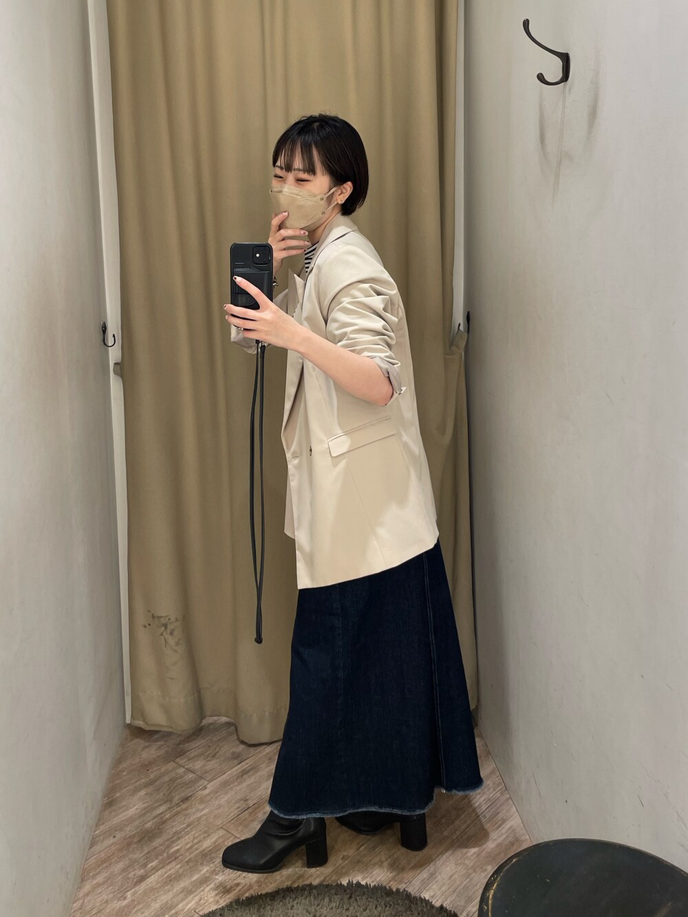 ブラック系のTシャツ/カットソー、ベージュ系のテーラードジャケット、ブルー系のスカートを着用したレディースの秋コーディネートの2枚目の写真