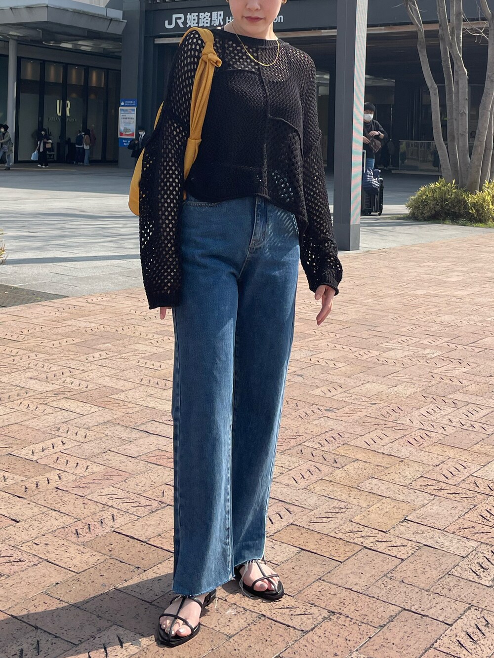 ブラック系のカーディガン/ボレロ、ブルー系のデニムパンツ、ブラック系のサンダルを着用したレディースの春コーディネートの2枚目の写真