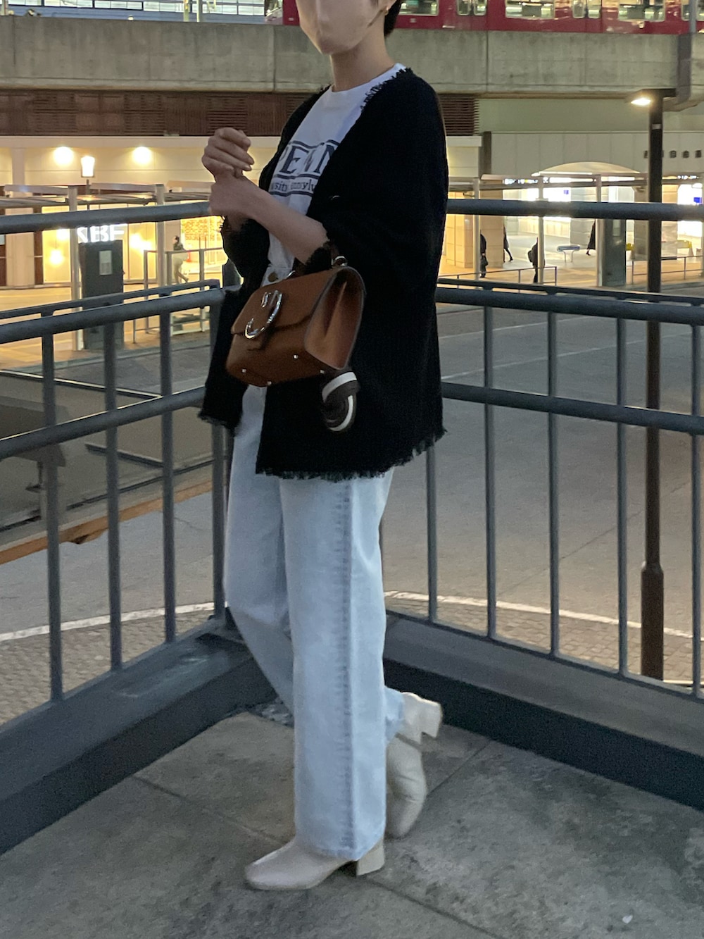 ブルー系のデニムパンツ、ホワイト系のTシャツ/カットソー、ブラック系のカーディガン/ボレロを着用したレディースの冬コーディネートの2枚目の写真