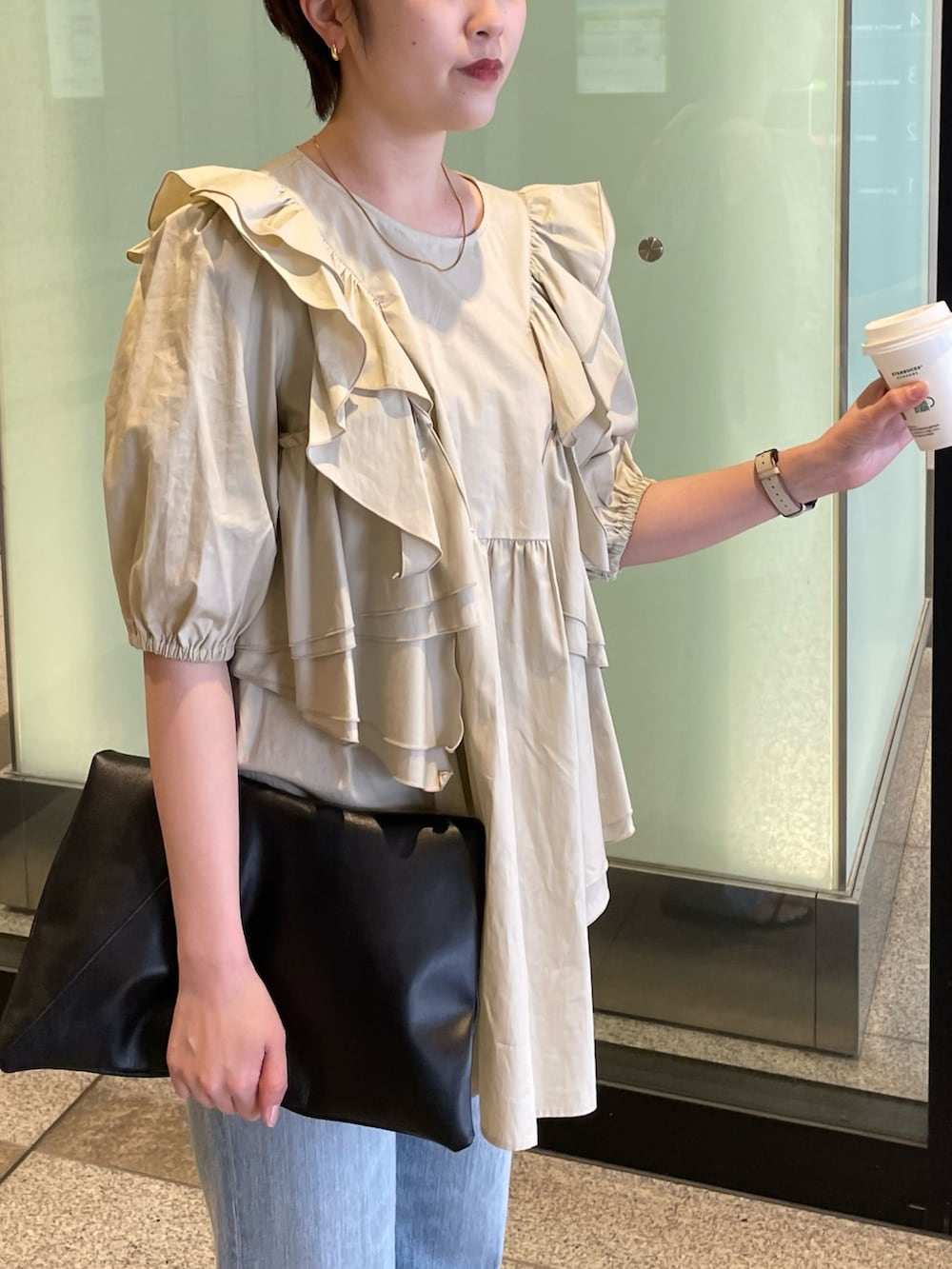 ベージュ系のシャツ/ブラウス、ブルー系のデニムパンツを着用したレディースの春コーディネートの2枚目の写真