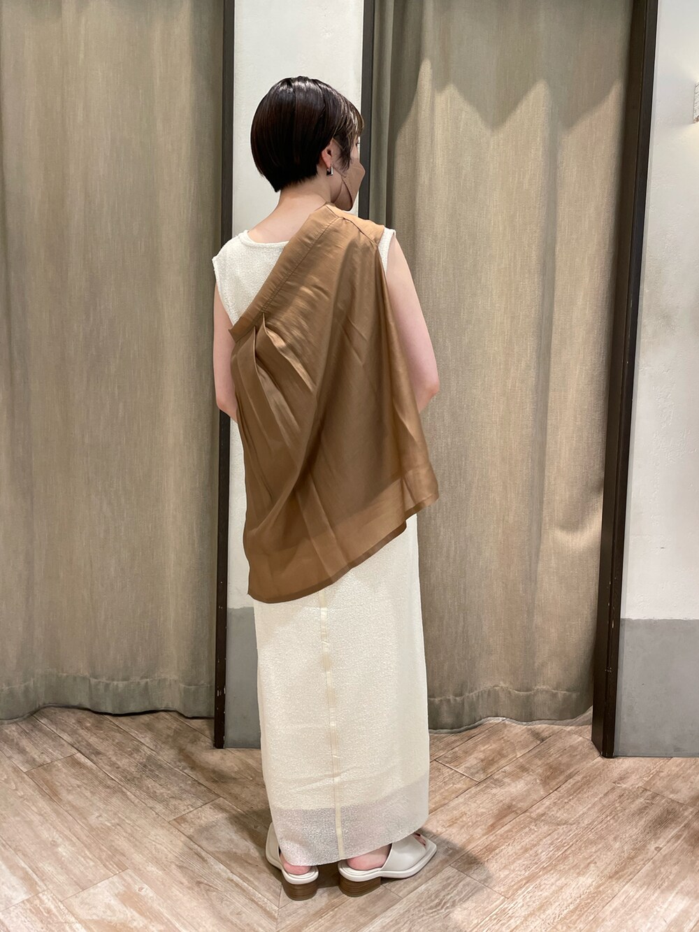 ホワイト系のワンピース、ホワイト系のサンダル、ブラウン系のシャツ/ブラウスを着用したレディースの夏コーディネートの2枚目の写真