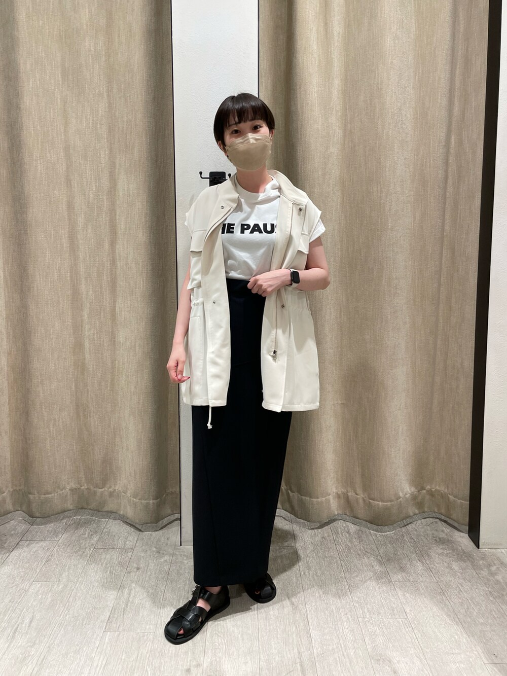 ブラック系のベスト、ブラック系のスカートを着用したレディースの春コーディネートの2枚目の写真