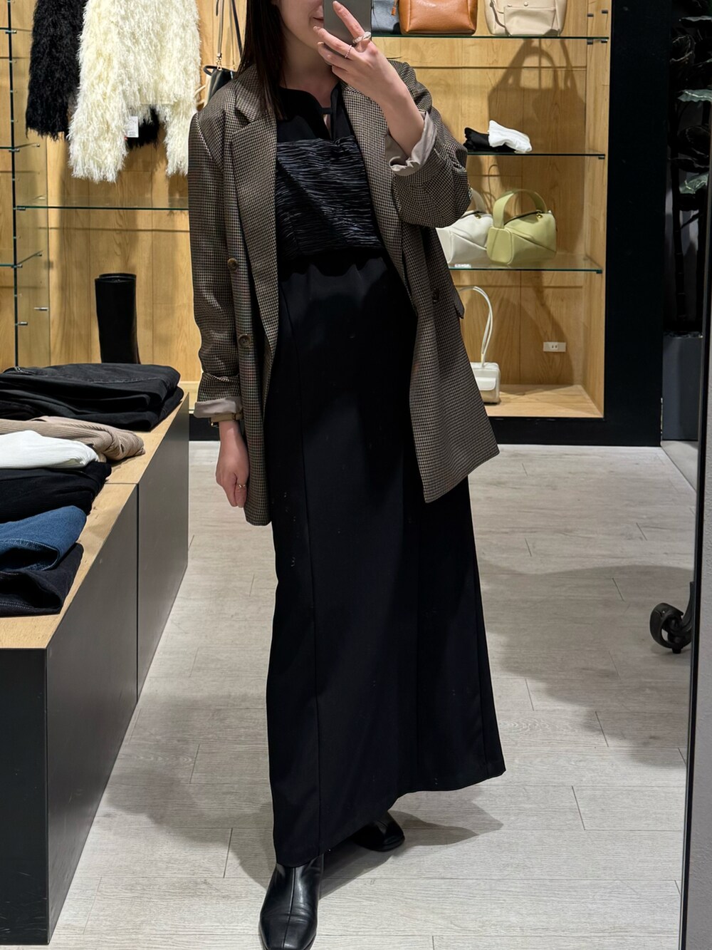 ブラウン系のテーラードジャケット、ブラック系のワンピースを着用したレディースの冬コーディネートの2枚目の写真