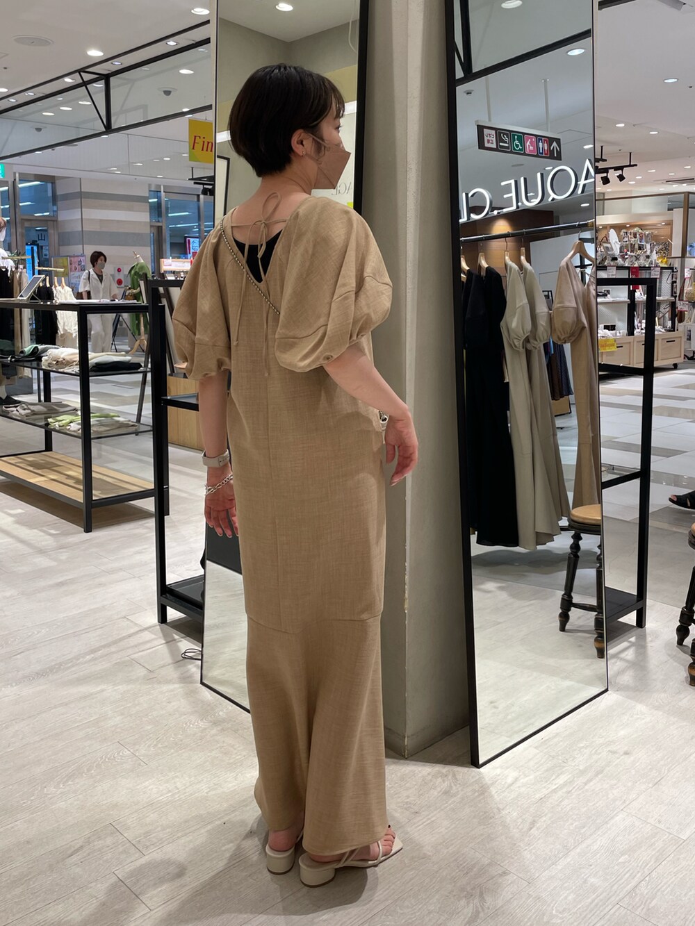 イエロー系のワンピース、ホワイト系のサンダルを着用したレディースの夏コーディネートの2枚目の写真