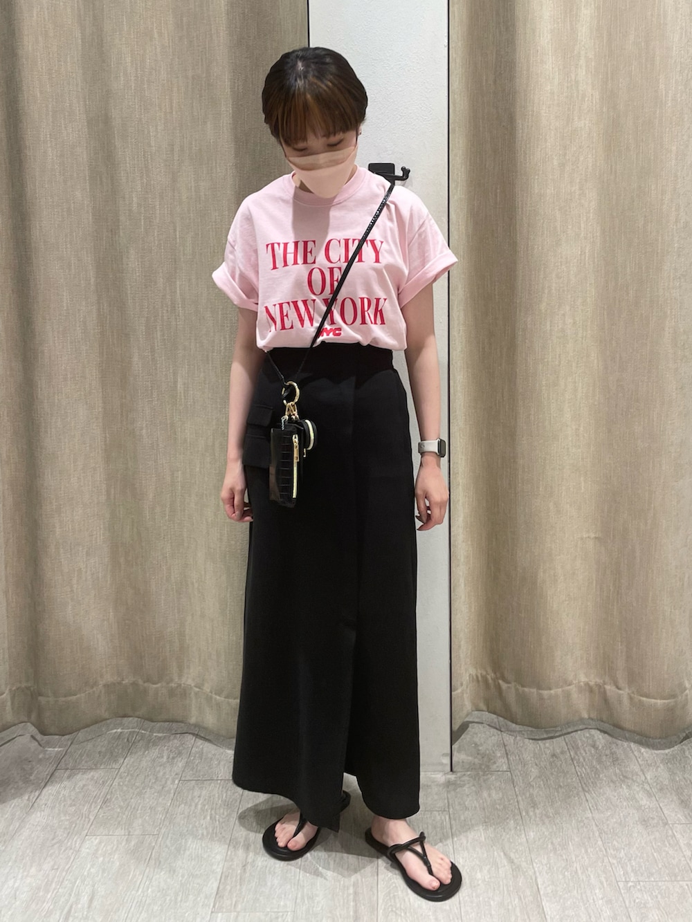 ピンク系のTシャツ/カットソー、ブラック系のスカート、ブラック系のサンダルを着用したレディースの夏コーディネートの2枚目の写真