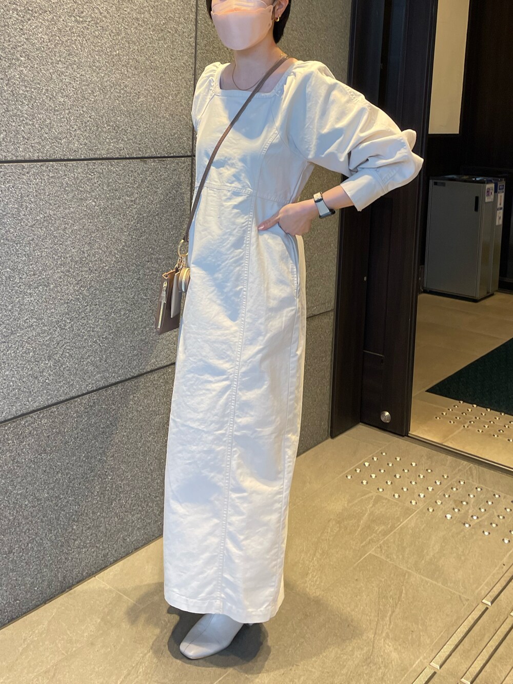 ホワイト系のワンピース、ベージュ系のショルダーバッグ、ホワイト系のカーディガン/ボレロを着用したレディースの冬コーディネートの2枚目の写真