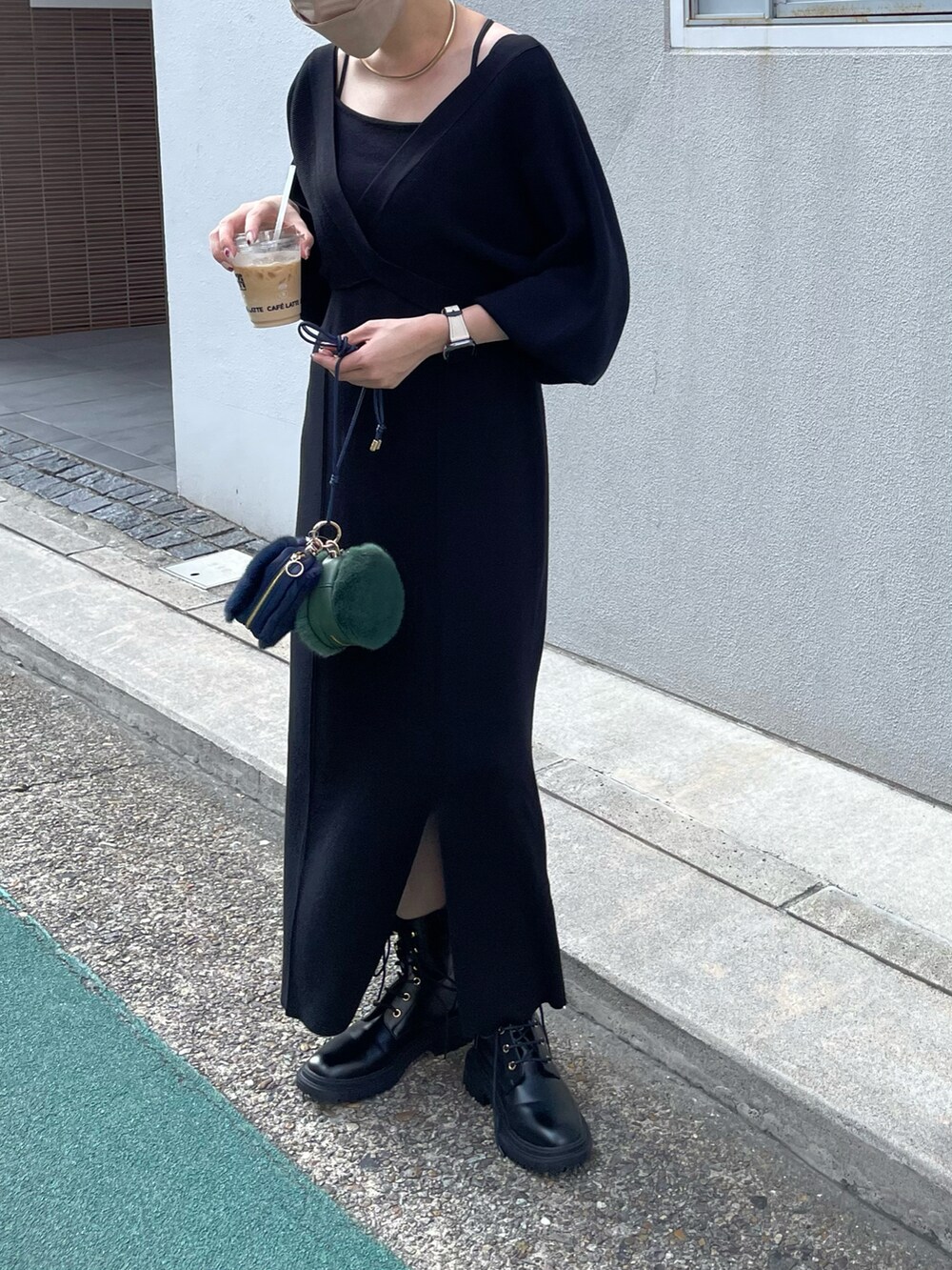 ブラック系のワンピース、ブラック系のブーツ、グリーン系のショルダーバッグを着用したレディースの秋コーディネートの3枚目の写真