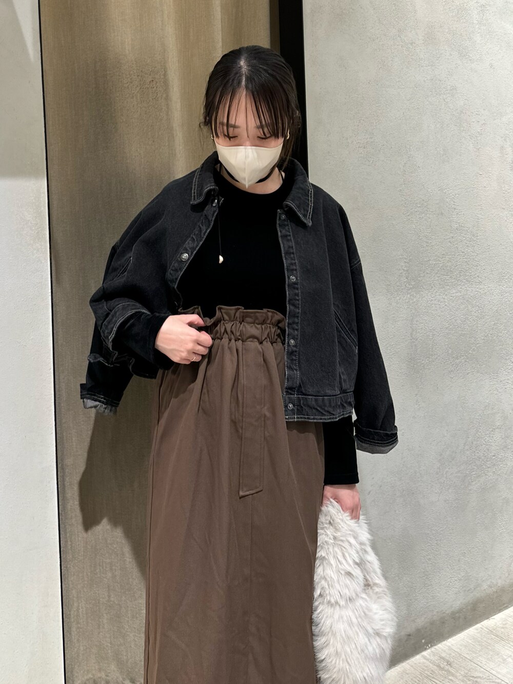 ブラック系のワンピース、ブラック系のブルゾン、ホワイト系のハンドバッグを着用したレディースの秋コーディネートの3枚目の写真