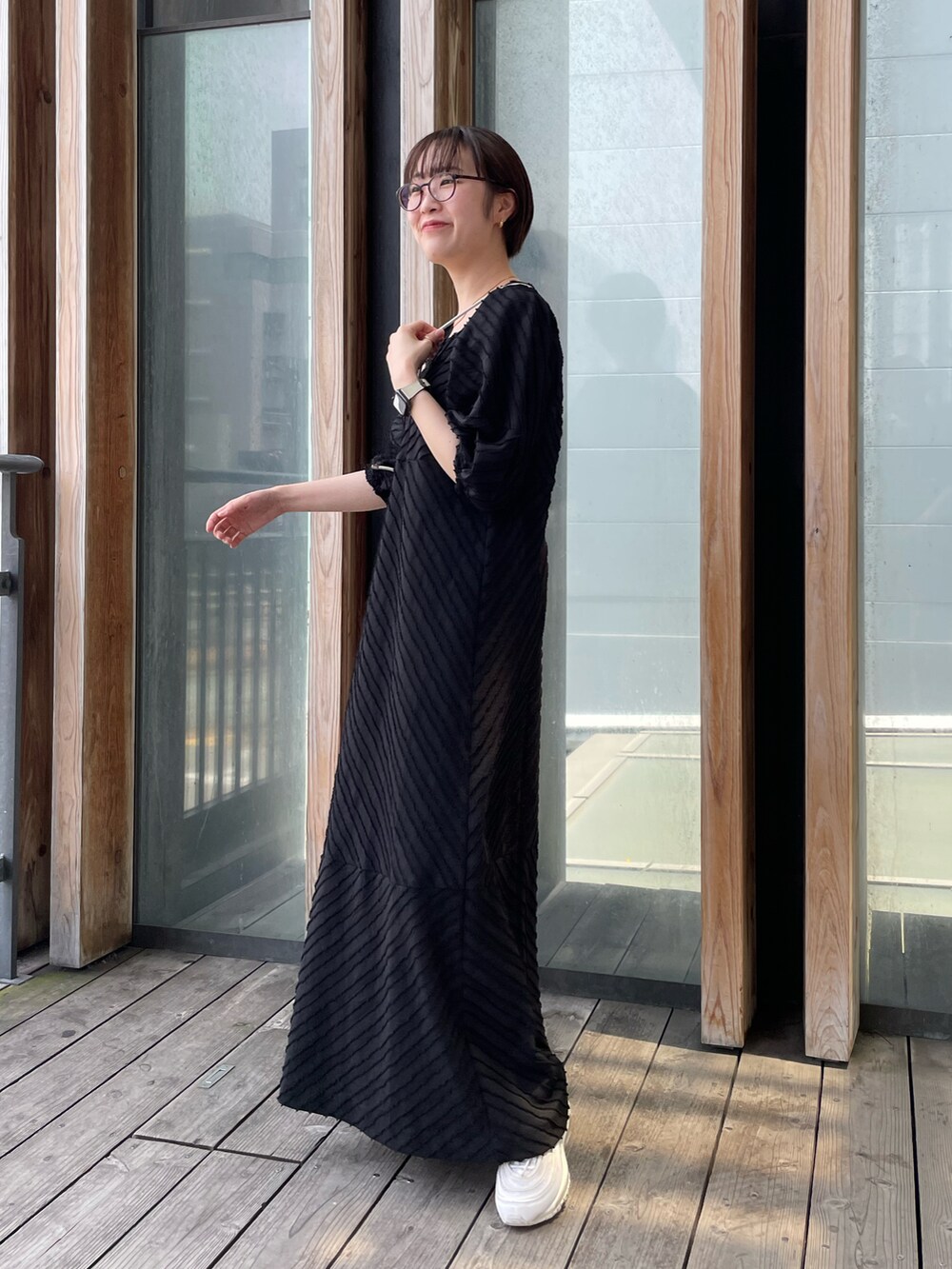 ブラック系のワンピースを着用したレディースの夏コーディネートの2枚目の写真