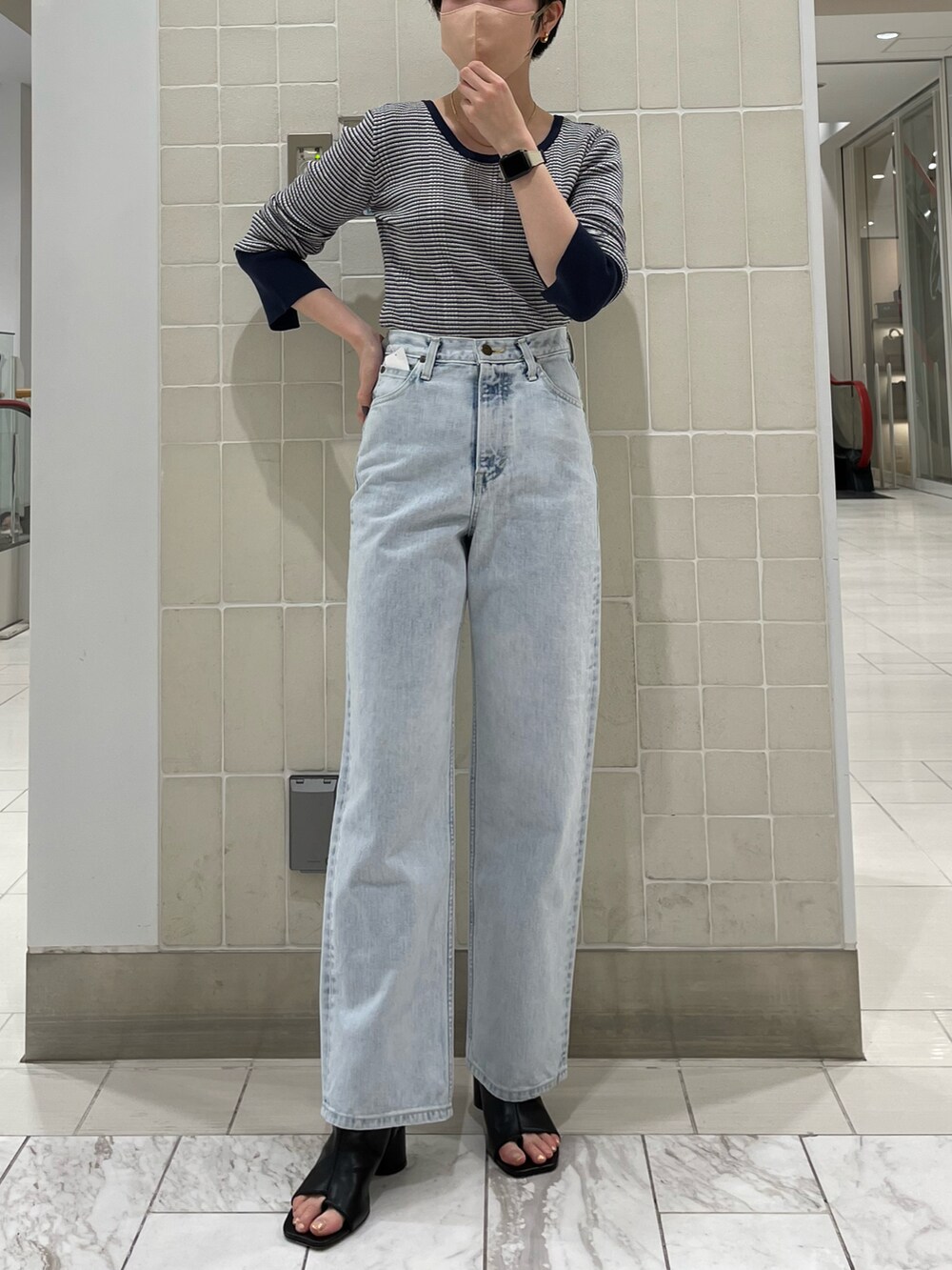 ホワイト系のトートバッグ、ブルー系のニット/セーター、ブルー系のデニムパンツを着用したレディースの冬コーディネートの2枚目の写真