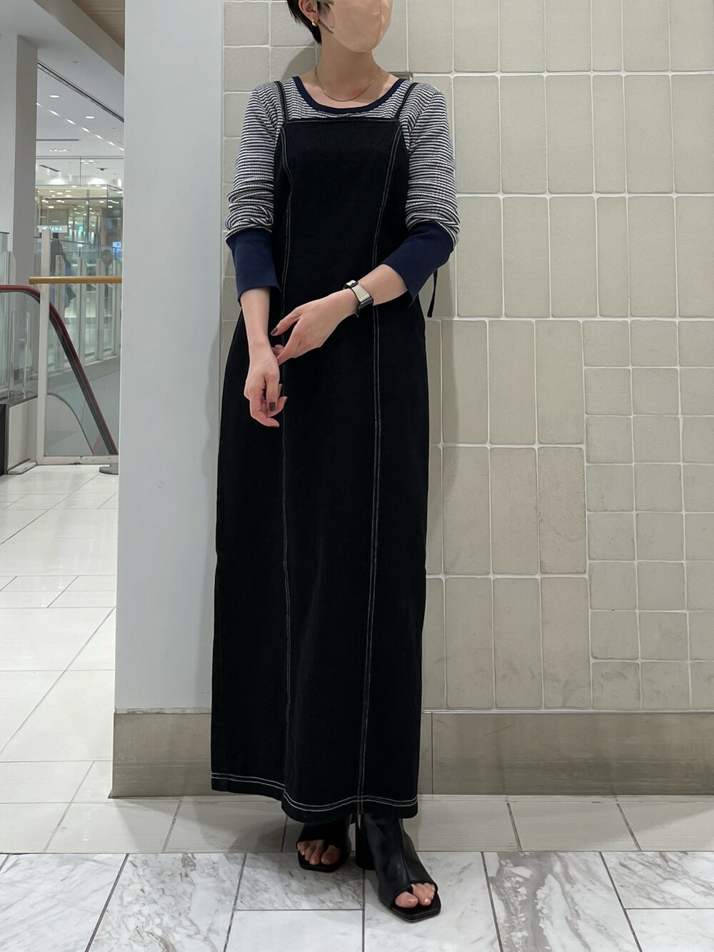 ブラック系のワンピース、ブルー系のニット/セーター、グリーン系のハンドバッグを着用したレディースの冬コーディネートの2枚目の写真