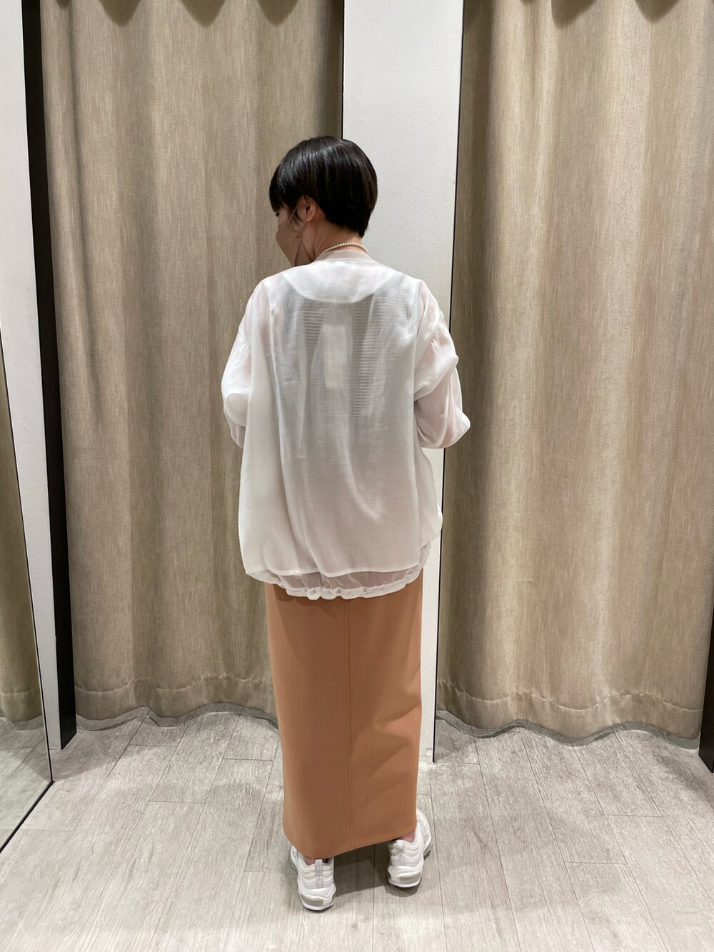 ブラウン系のTシャツ/カットソー、ホワイト系のブルゾン、オレンジ系のスカートを着用したレディースの春コーディネートの2枚目の写真