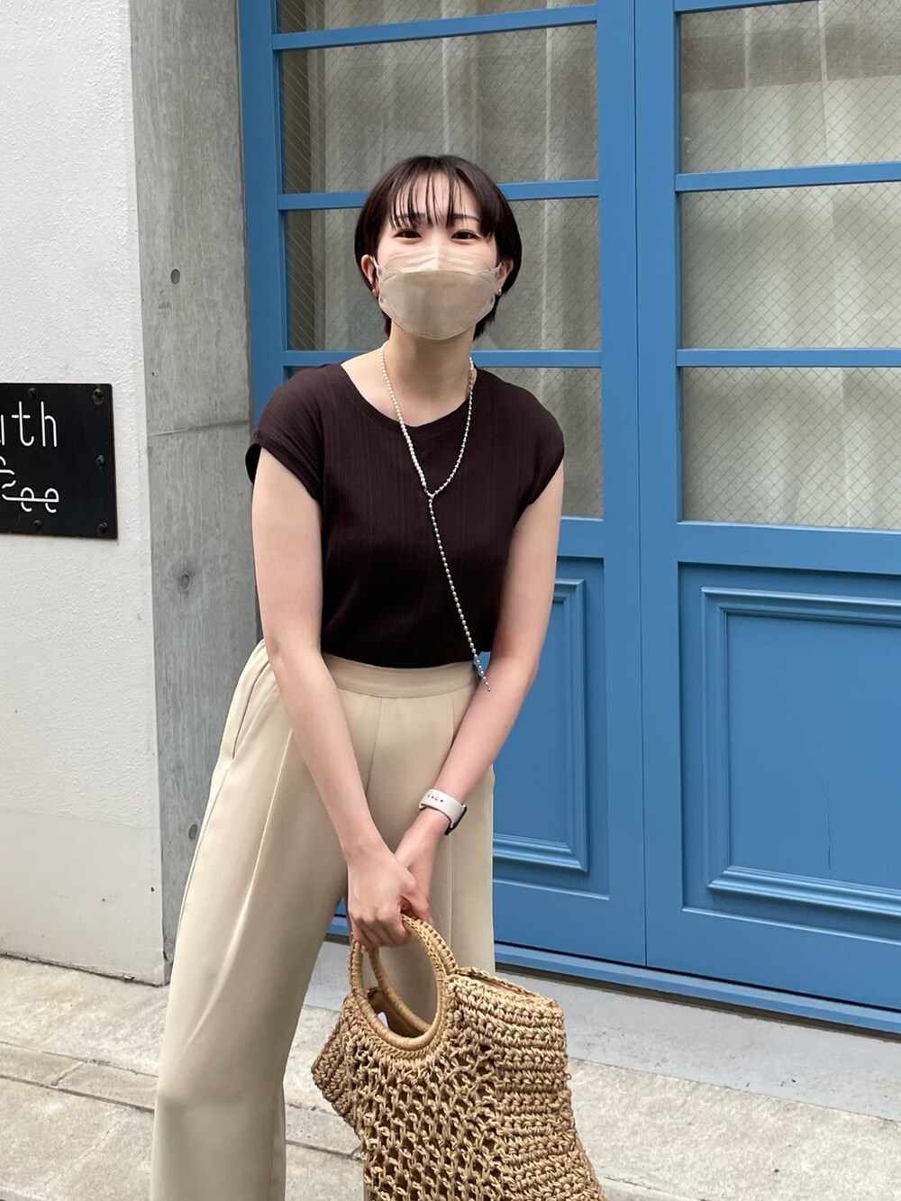 グレー系のTシャツ/カットソー、ベージュ系のトートバッグ、ホワイト系のサンダルを着用したレディースの春コーディネートの2枚目の写真