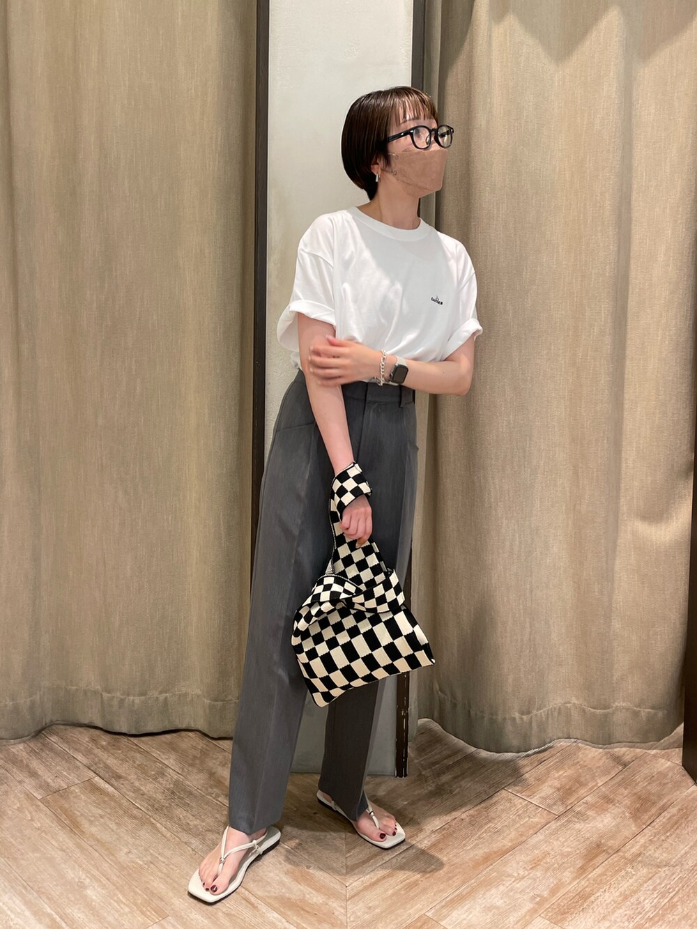 グレー系のスラックスを着用したレディースの夏コーディネートの2枚目の写真