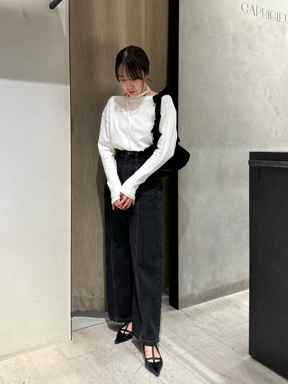 ブラック系のTシャツ/カットソー、ブラック系のデニムパンツを着用したレディースの秋コーディネートの2枚目の写真