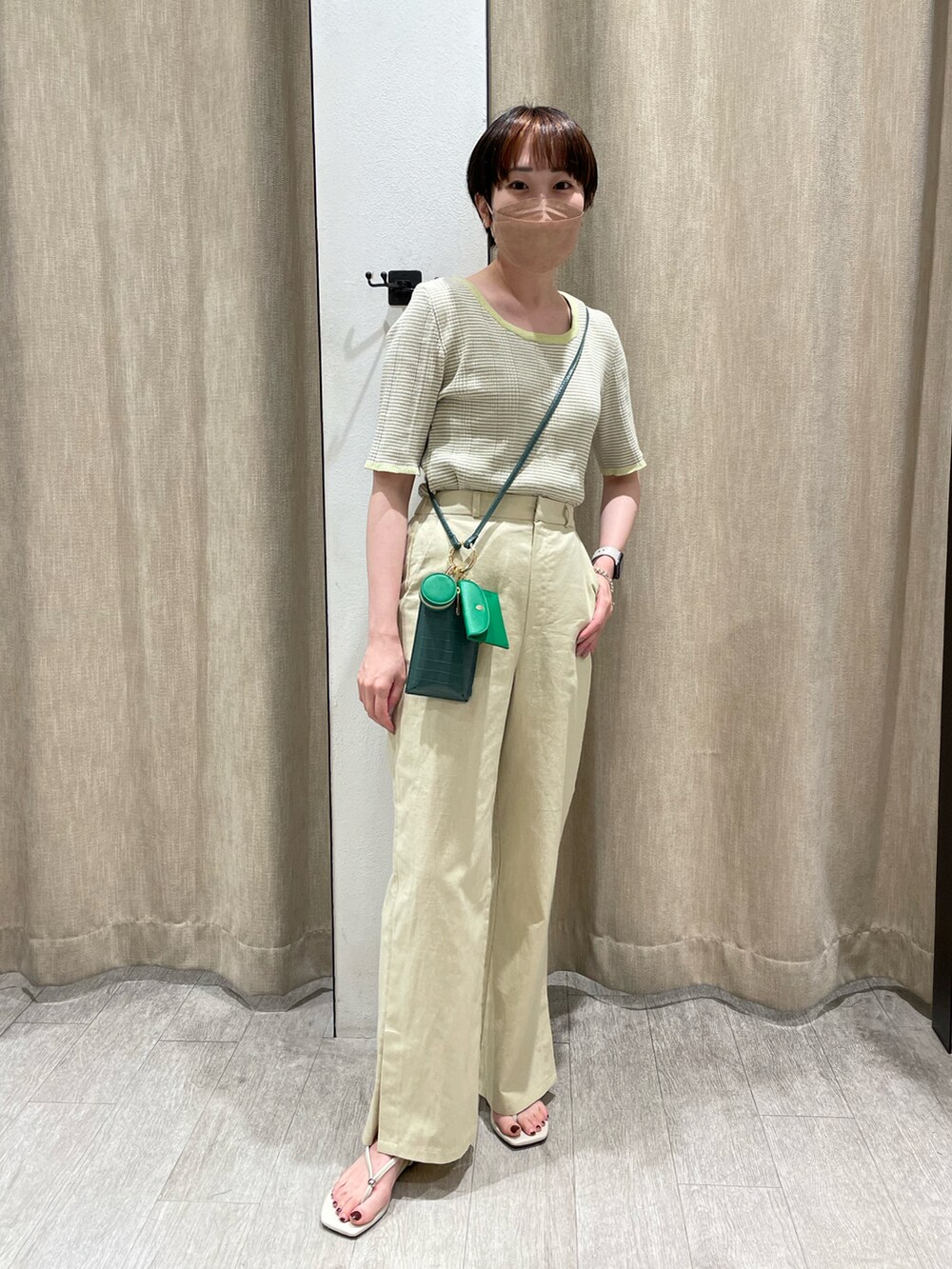 グリーン系のニット/セーター、ベージュ系のその他パンツ、ホワイト系のその他シューズを着用したレディースの春コーディネートの2枚目の写真