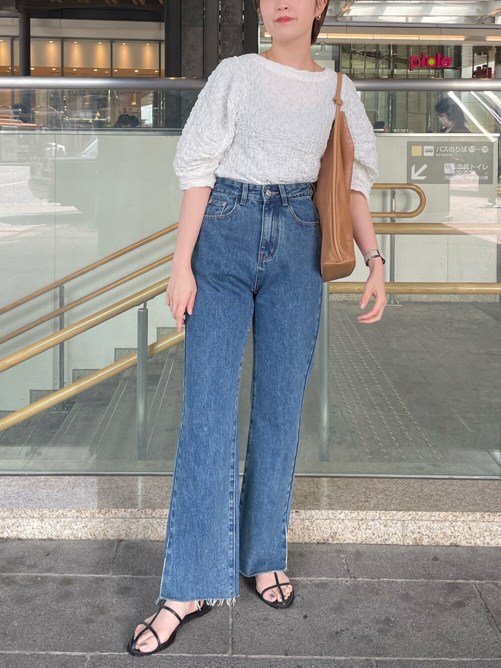 ホワイト系のTシャツ/カットソー、ブルー系のデニムパンツを着用したレディースの春コーディネートの2枚目の写真