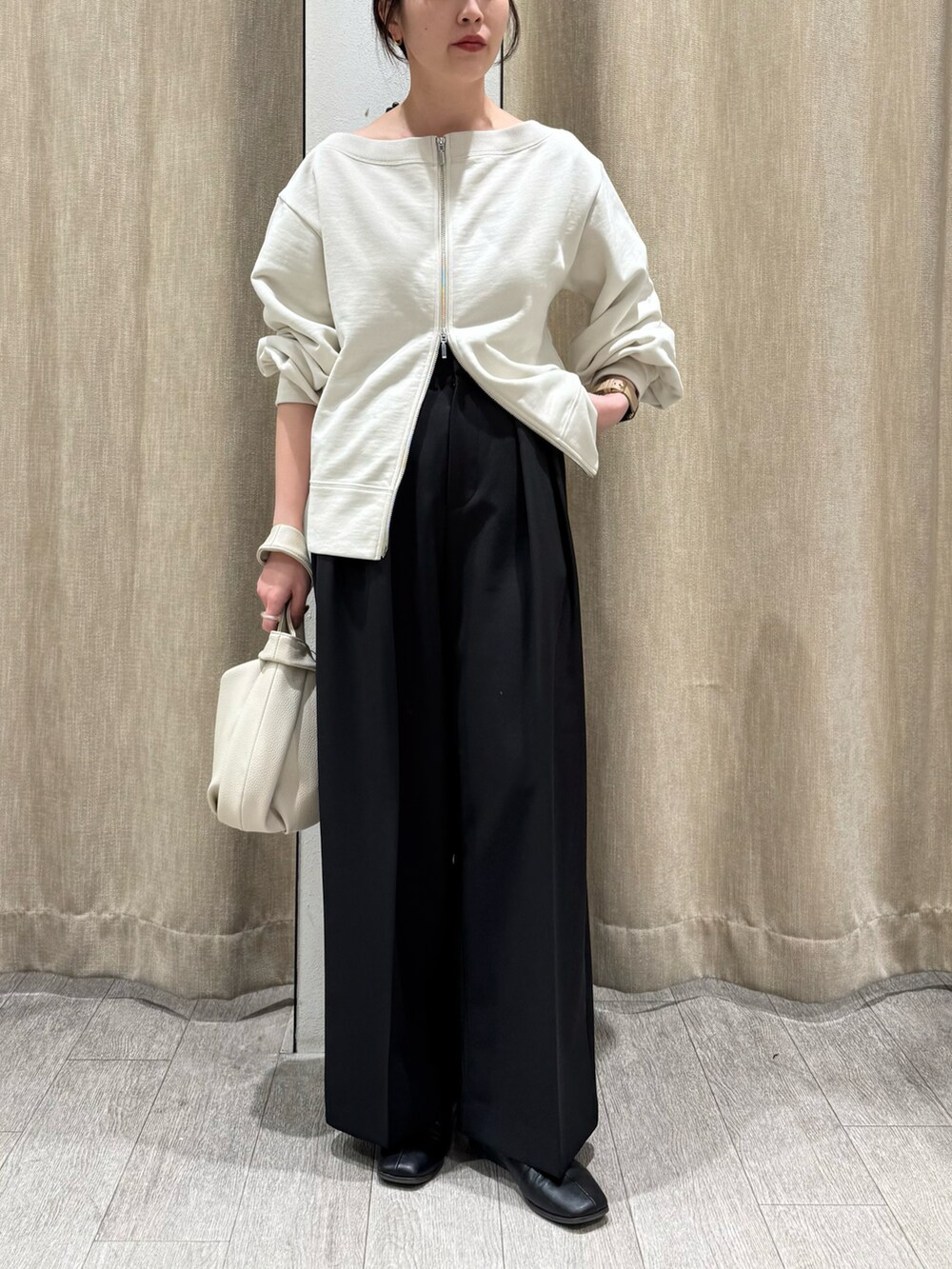 ブラック系のニット/セーター、ブラック系のその他パンツ、ホワイト系のハンドバッグを着用したレディースの冬コーディネートの2枚目の写真