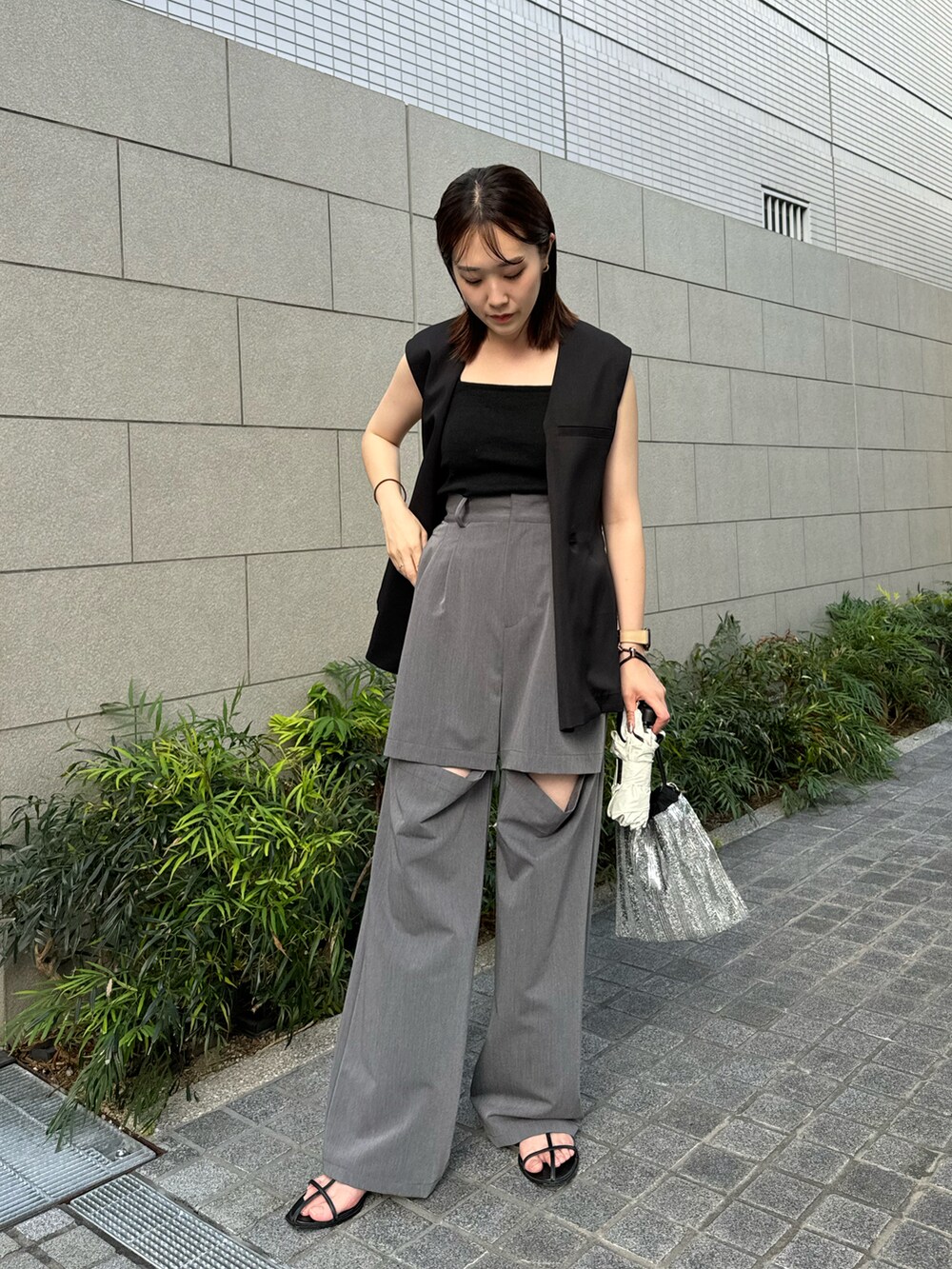 ブラック系のキャミソール、ブラック系のジャケット/アウター、グレー系のパンツを着用したレディースの夏コーディネートの2枚目の写真