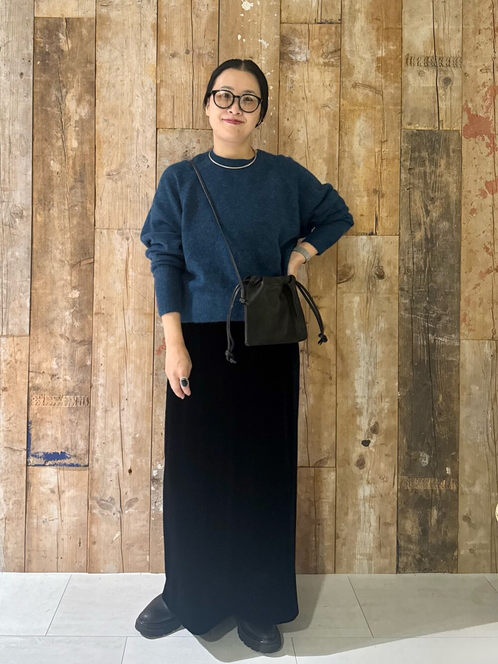 ブルー系のニット/セーター、ブラック系のスカート、ブラック系のショルダーバッグを着用したレディースの冬コーディネートの3枚目の写真