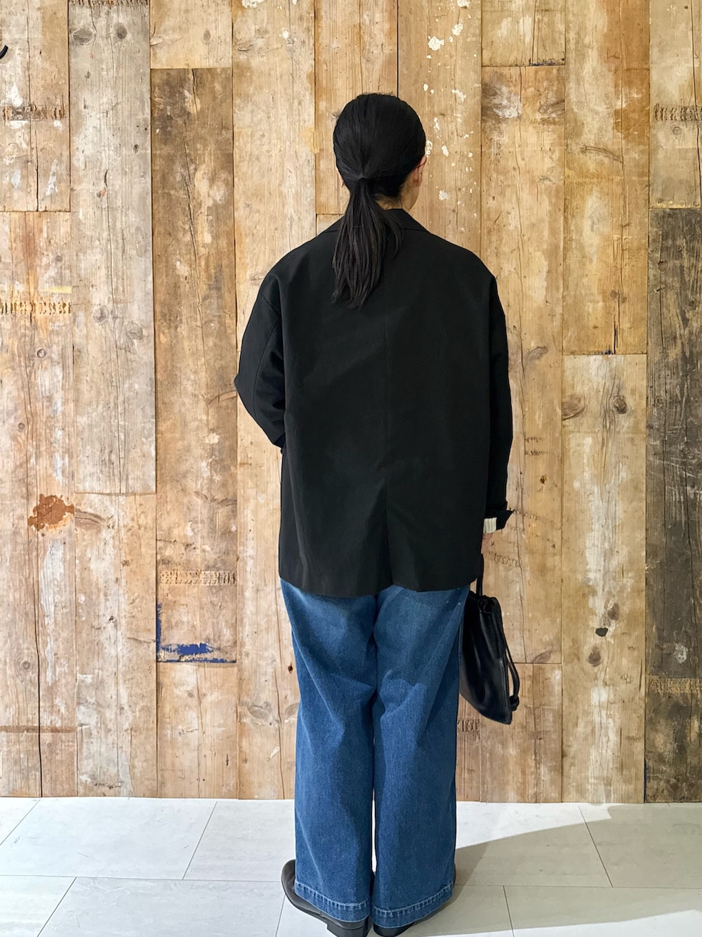 ブラック系のその他アウター、ホワイト系のキャミソール、ブルー系のデニムパンツを着用したレディースの秋コーディネートの3枚目の写真