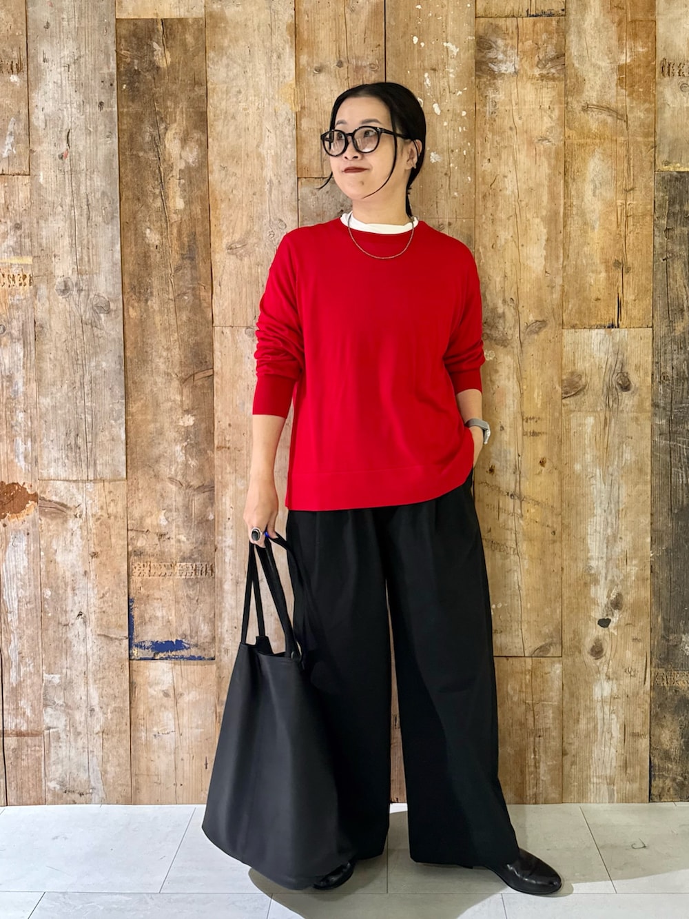 レッド系のニット/セーター、ホワイト系のTシャツ/カットソー、ブラック系のその他パンツを着用したレディースの秋コーディネートの2枚目の写真