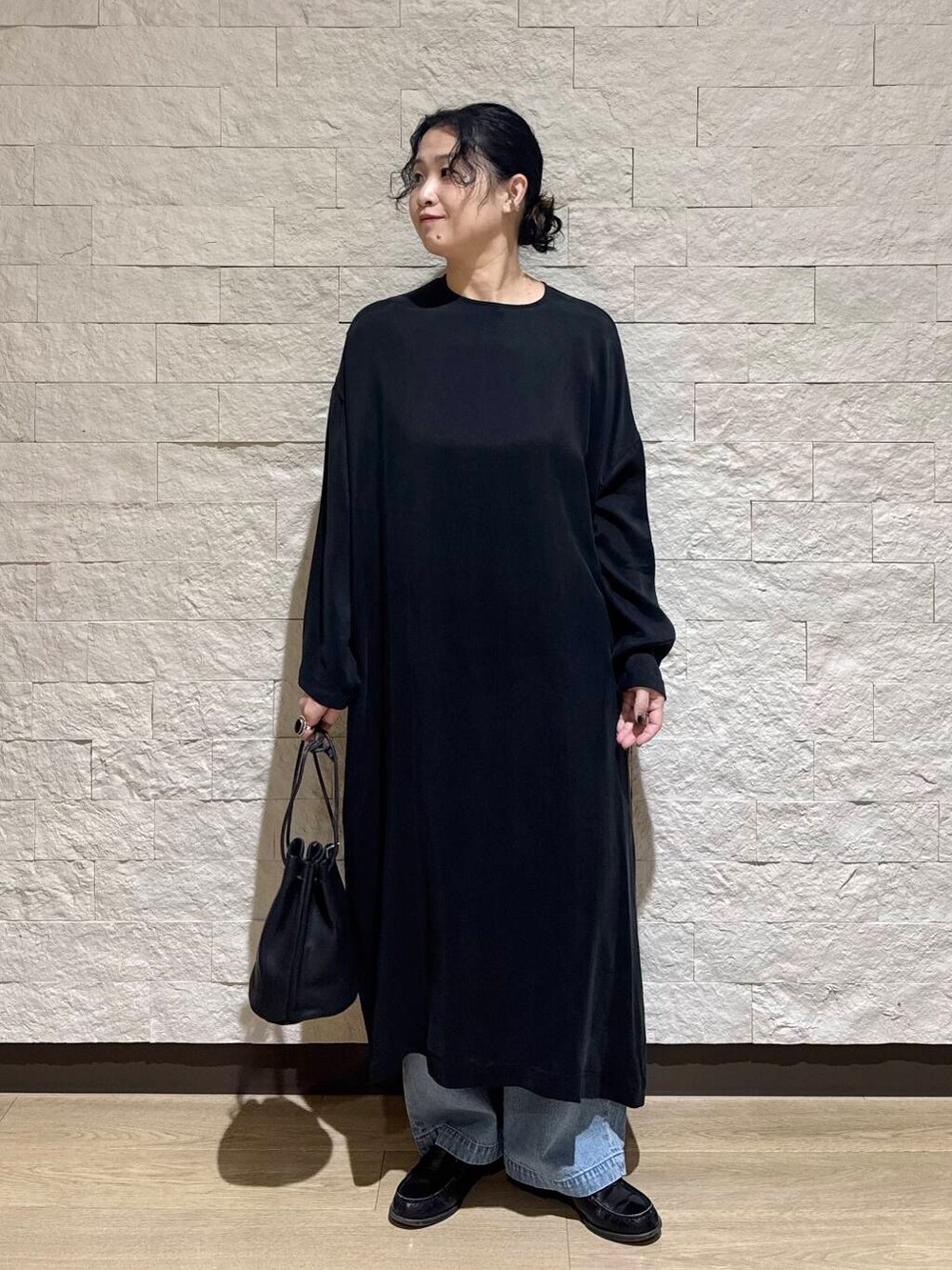 ブルー系のデニムパンツ、ブラック系のワンピースを着用したレディースの冬コーディネートの2枚目の写真