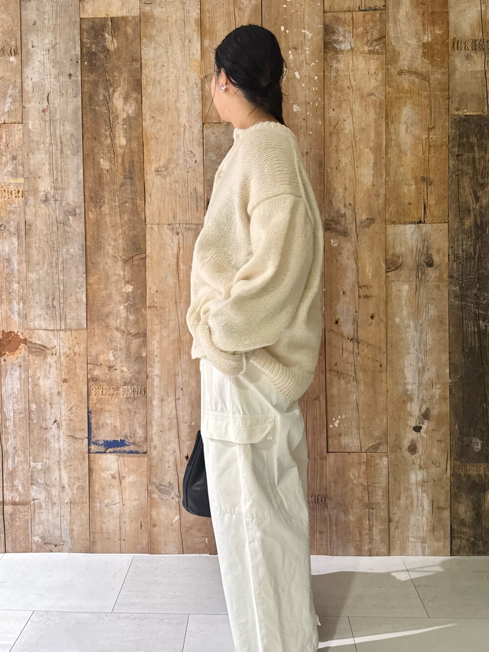 ホワイト系のその他パンツ、ホワイト系のニット/セーター、ブラック系のハンドバッグを着用したレディースの秋コーディネートの2枚目の写真