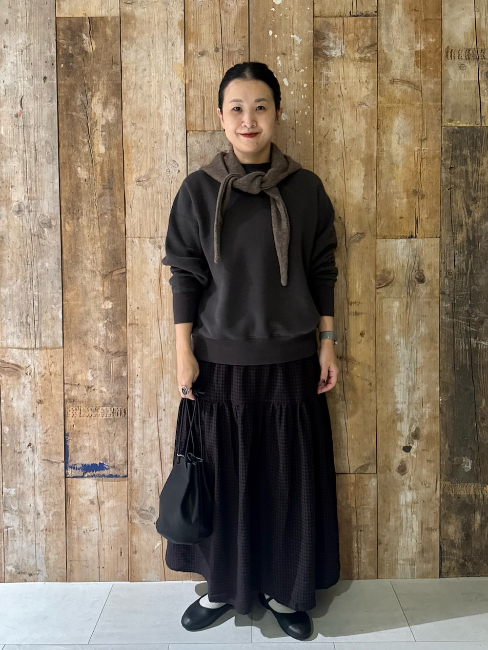 グレー系のスウェット、ブラウン系のスカート、ブラック系のバレエシューズを着用したレディースの冬コーディネートの5枚目の写真