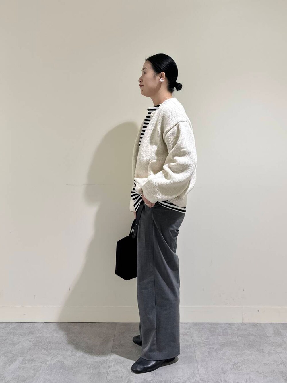 ホワイト系のニット/セーター、ブラック系のTシャツ/カットソー、グレー系のその他パンツを着用したレディースの秋コーディネートの3枚目の写真